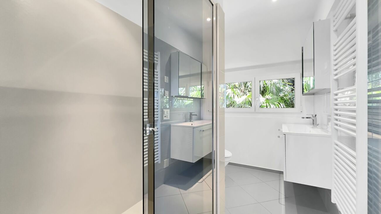 Modernes Badezimmer mit Dusche und Fensterblick