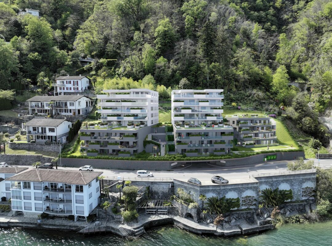 Luftaufnahme eines Seegrundstücks mit terrassierten Neubauten