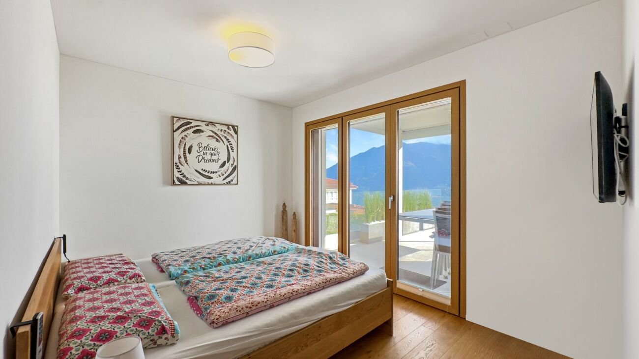 Helles Schlafzimmer mit Balkonzugang und Bergblick