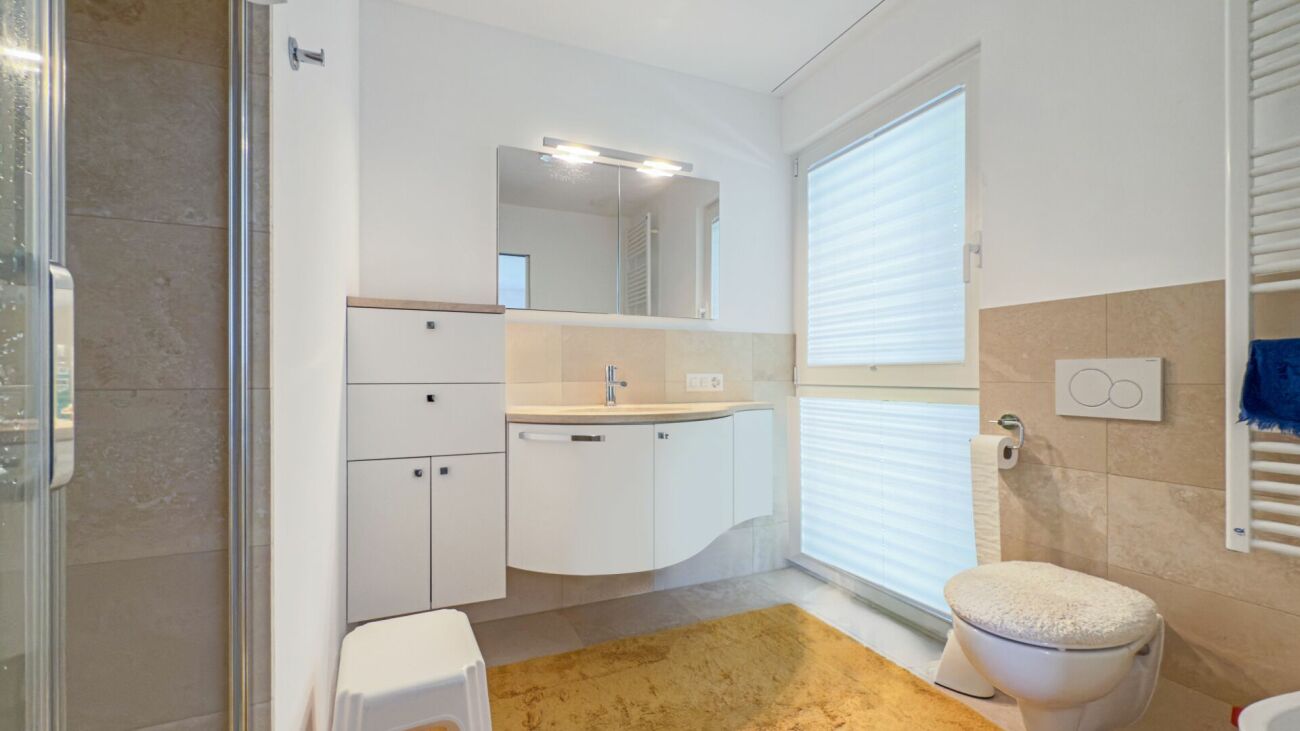 Modernes Badezimmer mit Dusche, Waschbereich und WC