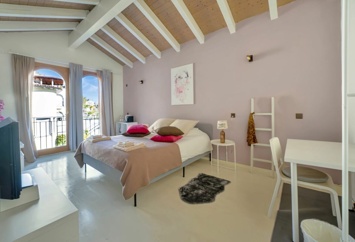 Helles Schlafzimmer mit Balkon und Dachbalken
