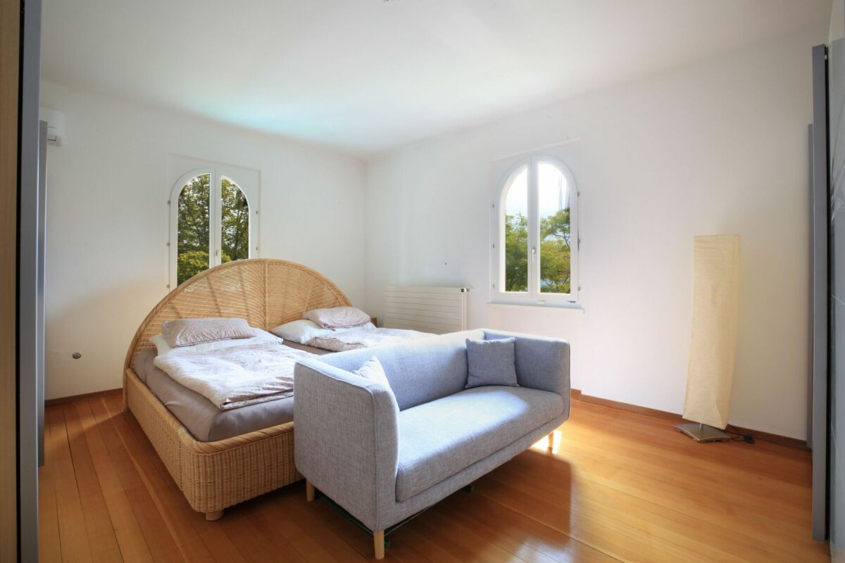 Helles Schlafzimmer mit Rattanbett und Sofa