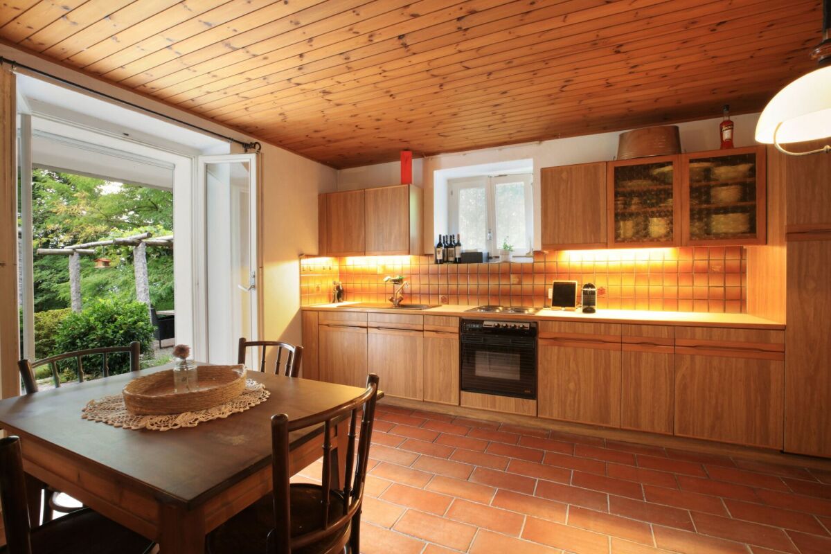 Gemütliche Küche mit Holzdecke und Gartenblick
