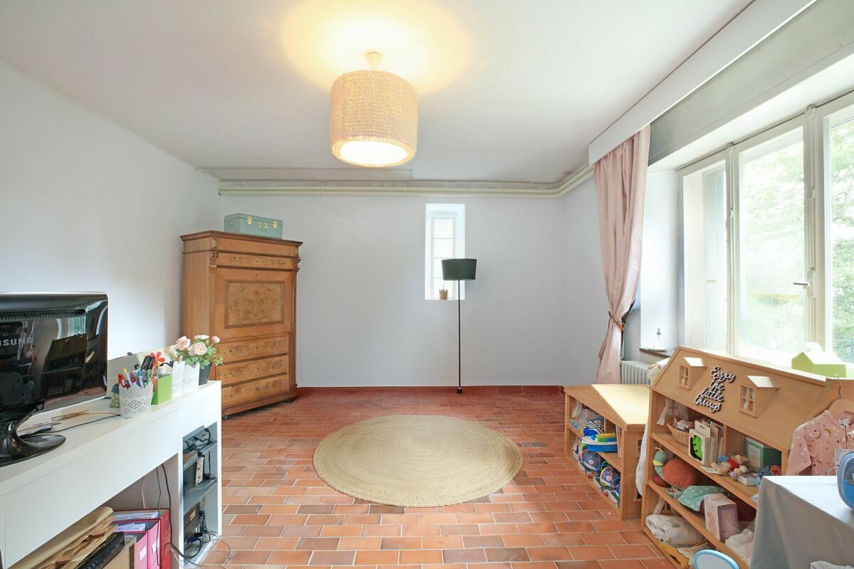 Wohnzimmer mit Terrakottaboden und großen Fenstern