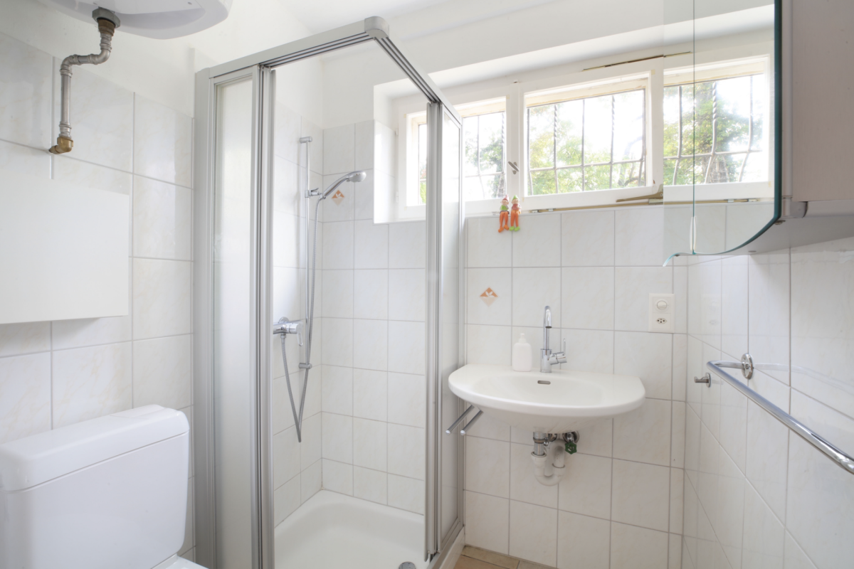 Helles Badezimmer mit Dusche und Fenster
