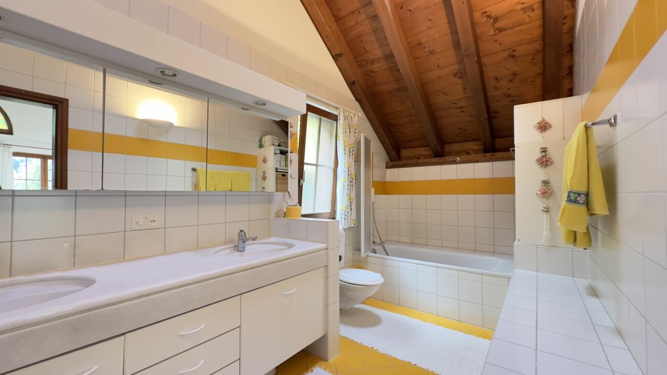 Badezimmer mit Holzdecke und gelben Akzenten