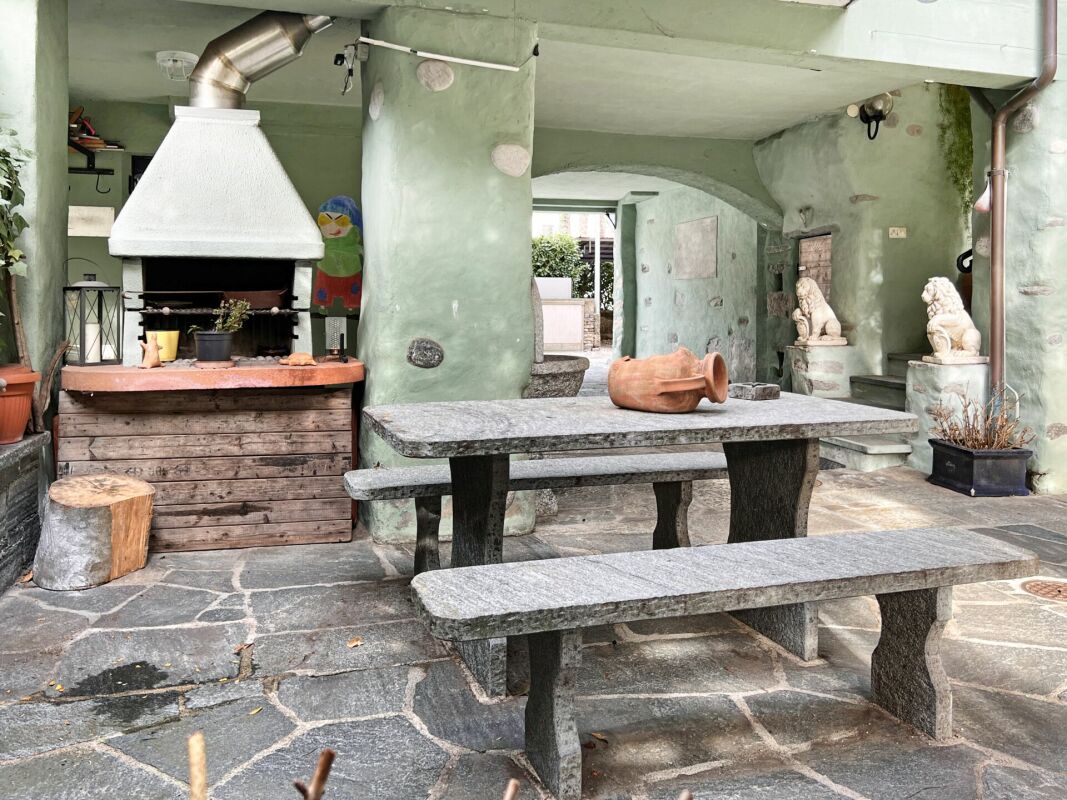 Außenbereich mit gemauertem Grill und Steintisch
