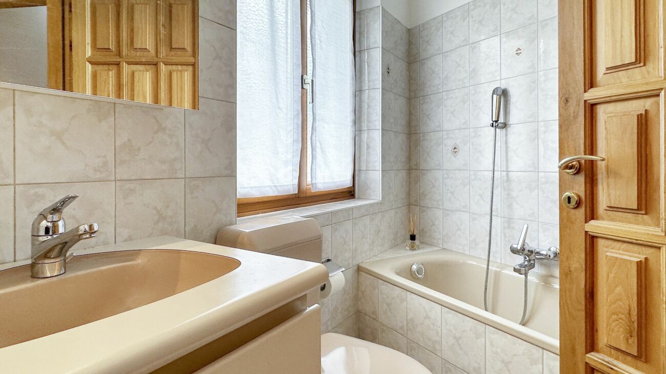 Kleines Badezimmer mit Badewanne und Waschbecken
