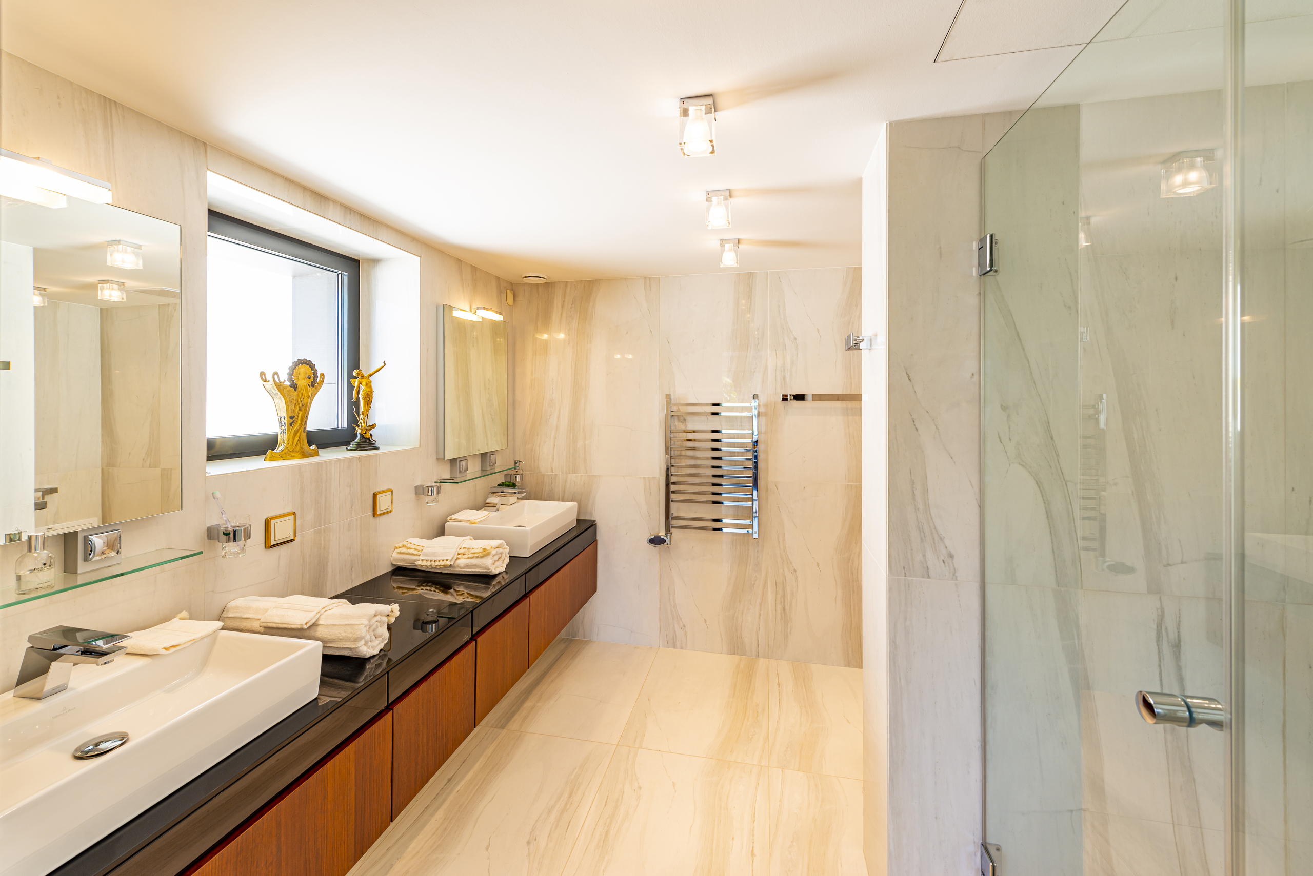 Luxuriöses Badezimmer mit Doppelwaschbecken und Glasdusche