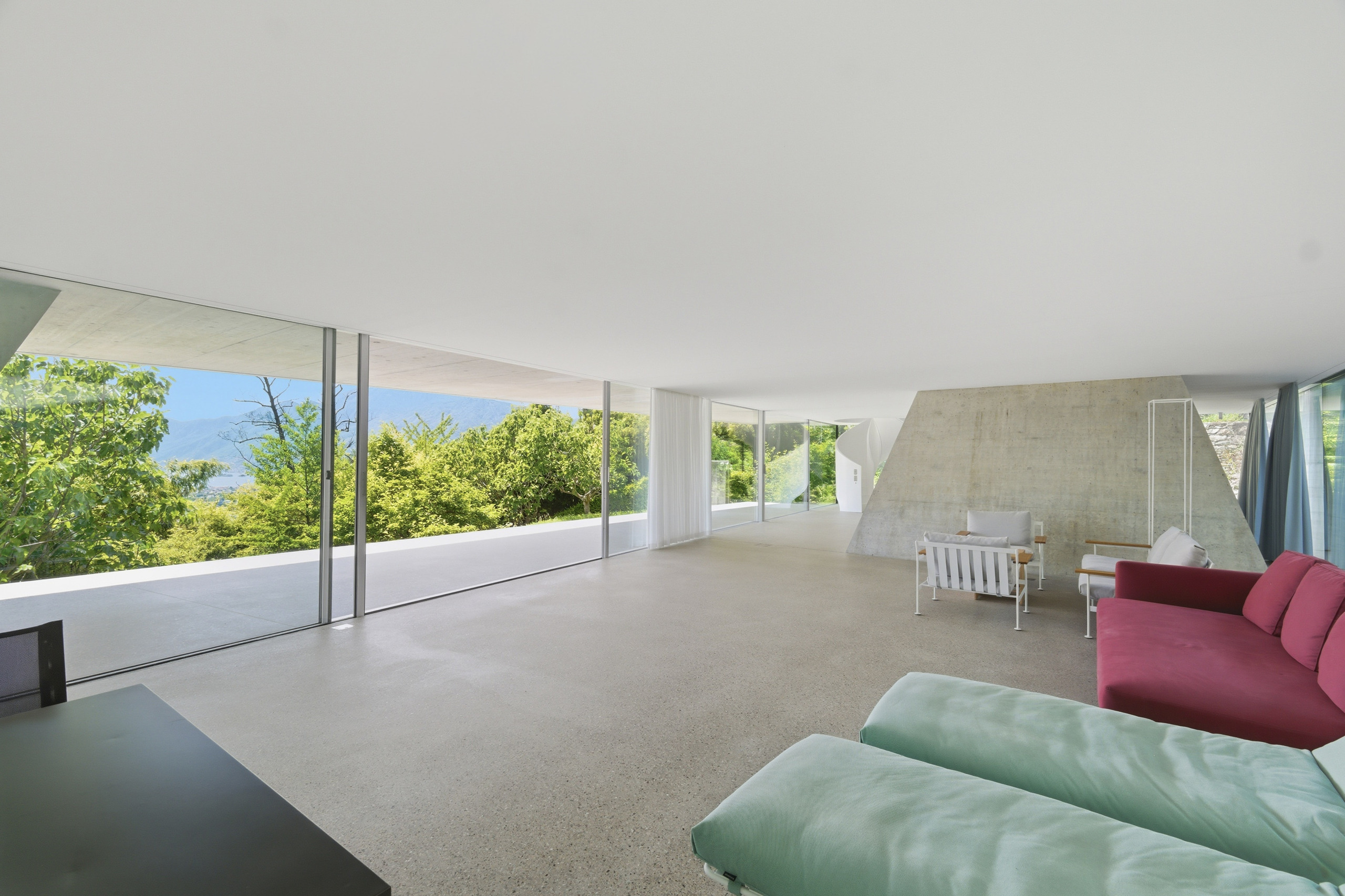 Modernes Wohnzimmer mit Panoramafenstern und Gartenblick