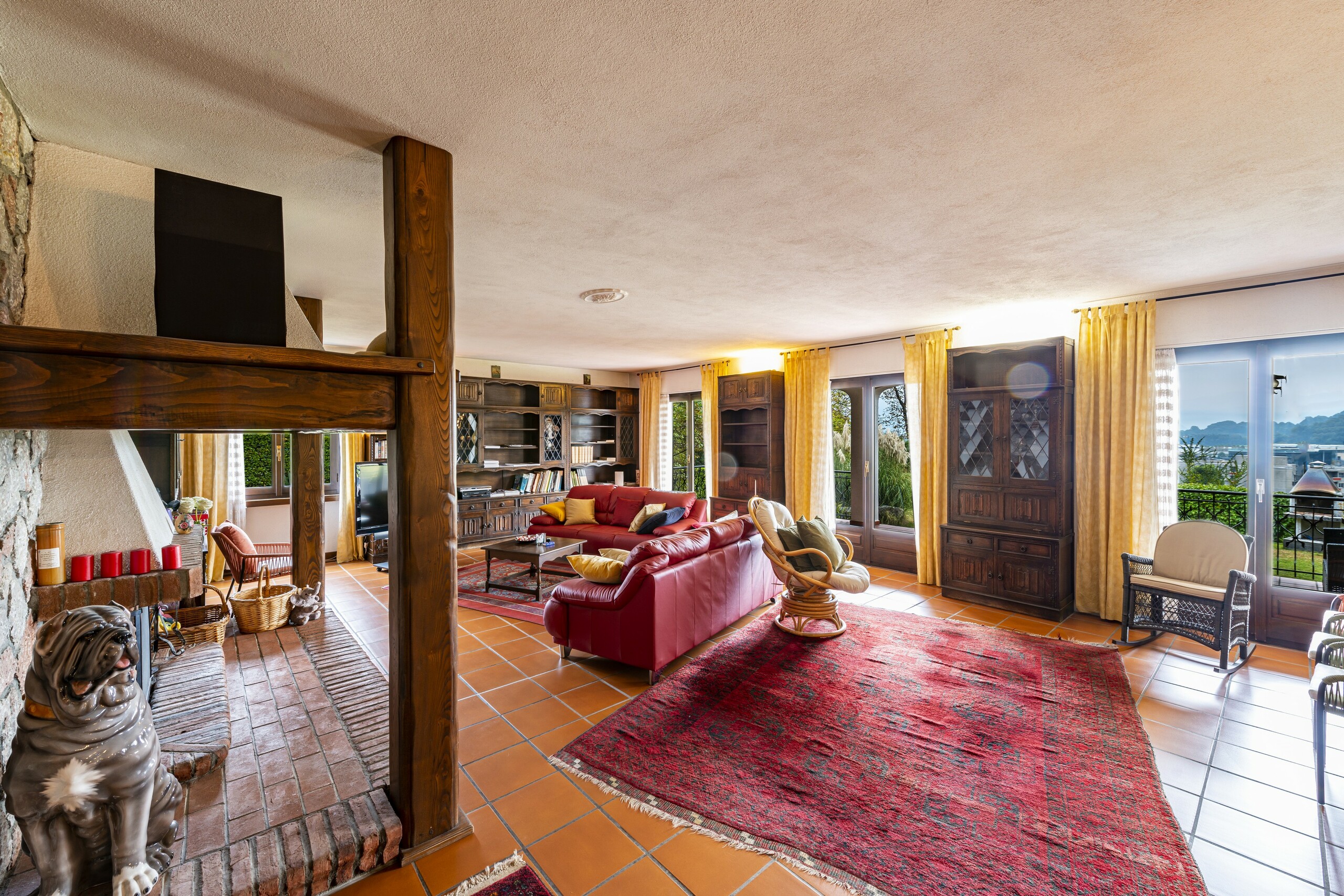 Wohnzimmer mit Kamin und Balkonblick