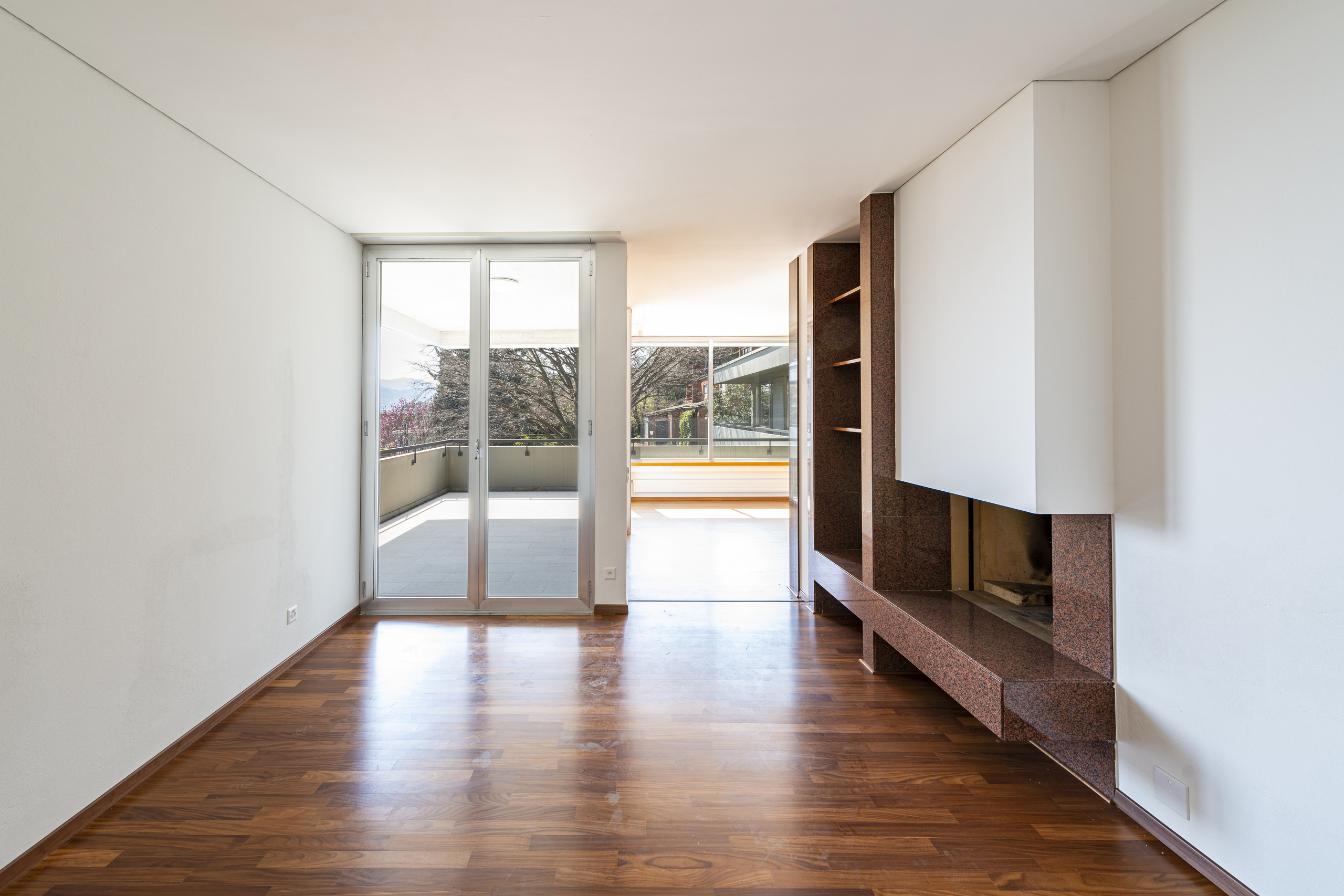 Helles Wohnzimmer mit Kamin und Balkonzugang