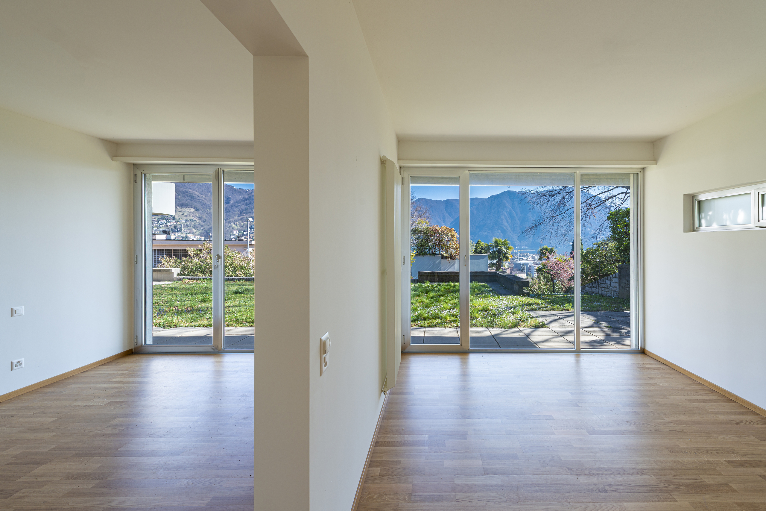 Heller Wohnraum mit großen Glasfronten und Bergblick