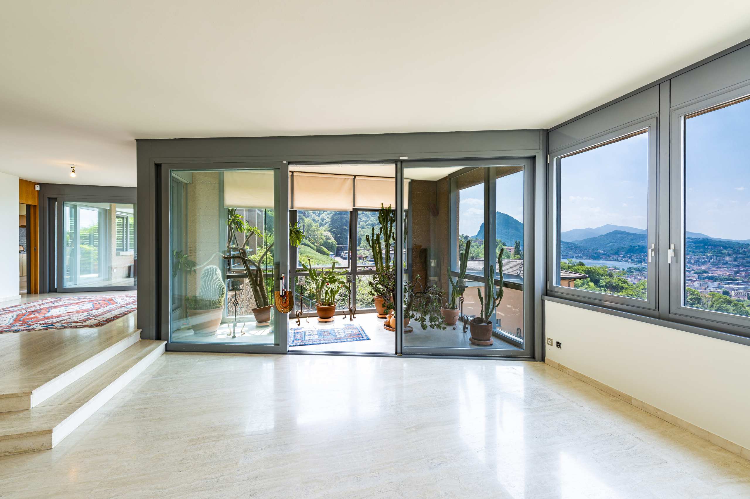 Heller Wohnraum mit großer Glasfront und Bergblick