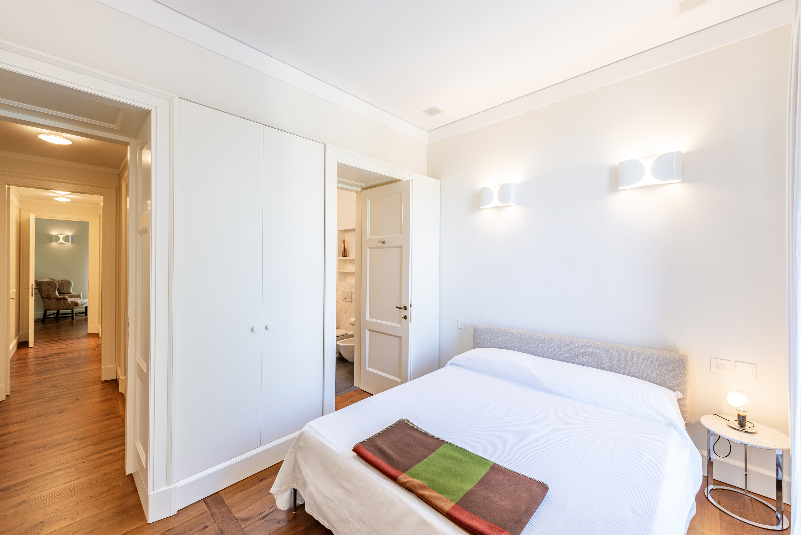 Helles Schlafzimmer mit angrenzendem Bad und Flur