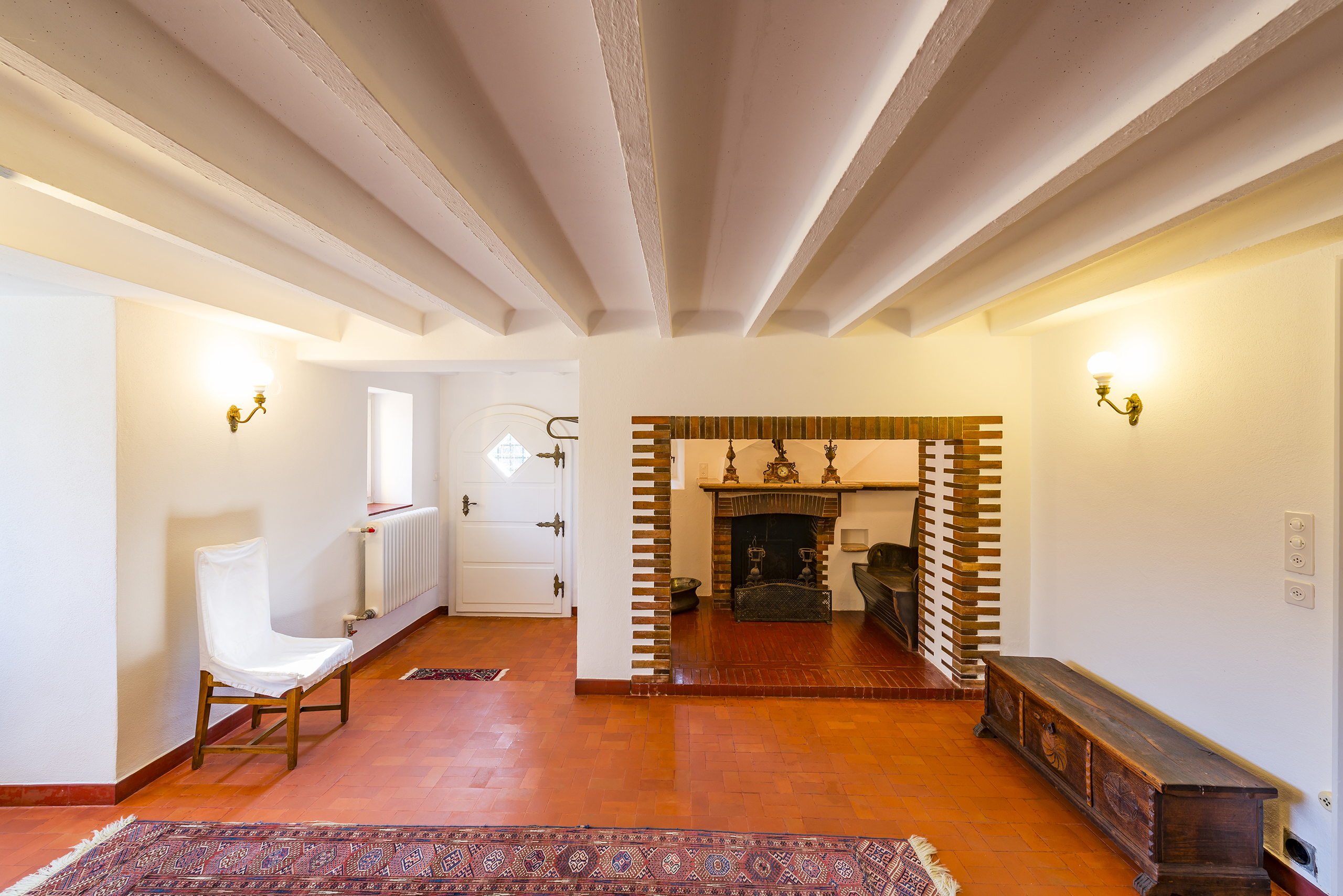 Wohnraum mit Kamin und Terrakottaboden
