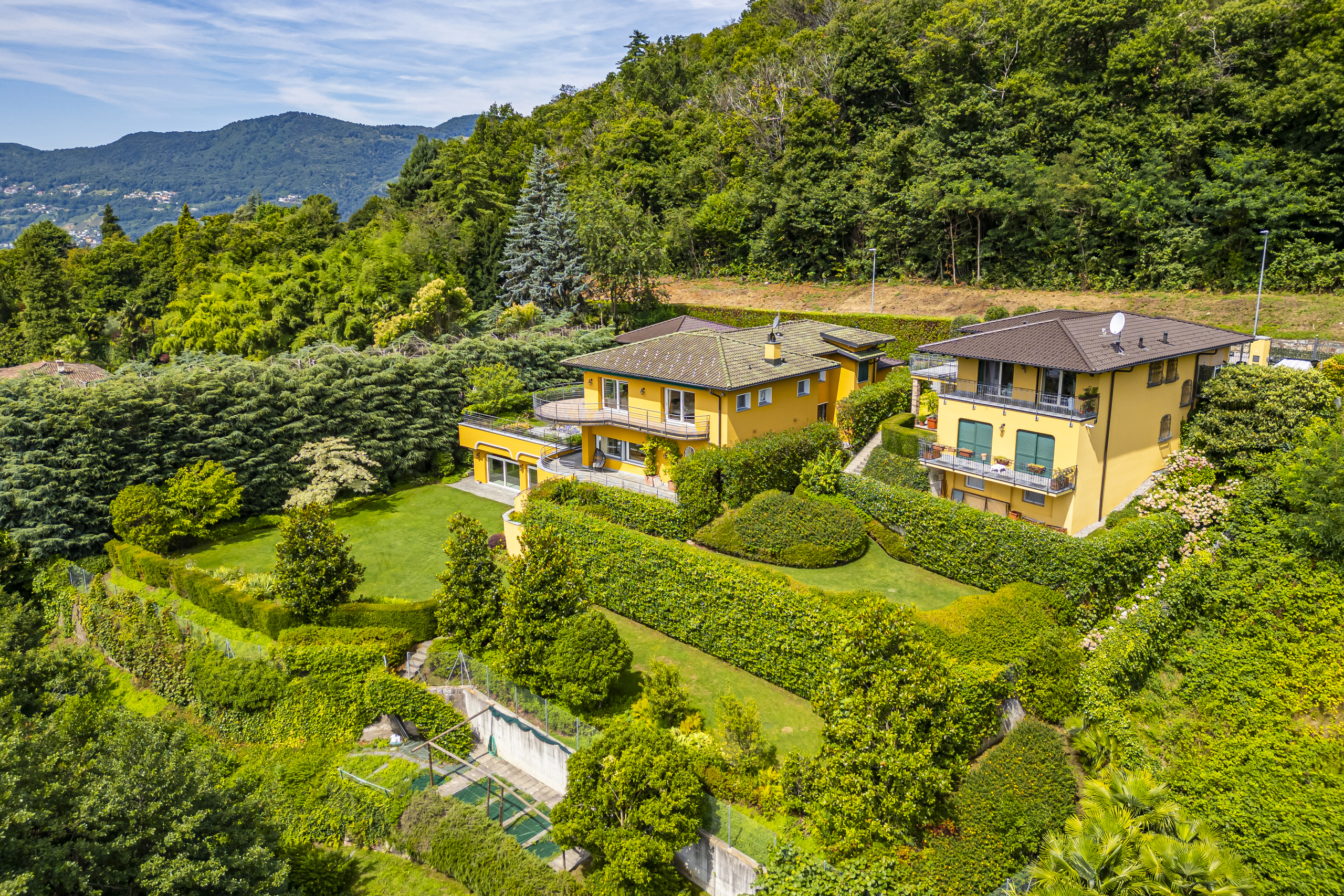 Hochwertige Luftaufnahme einer mediterran wirkenden Villa in Hanglage