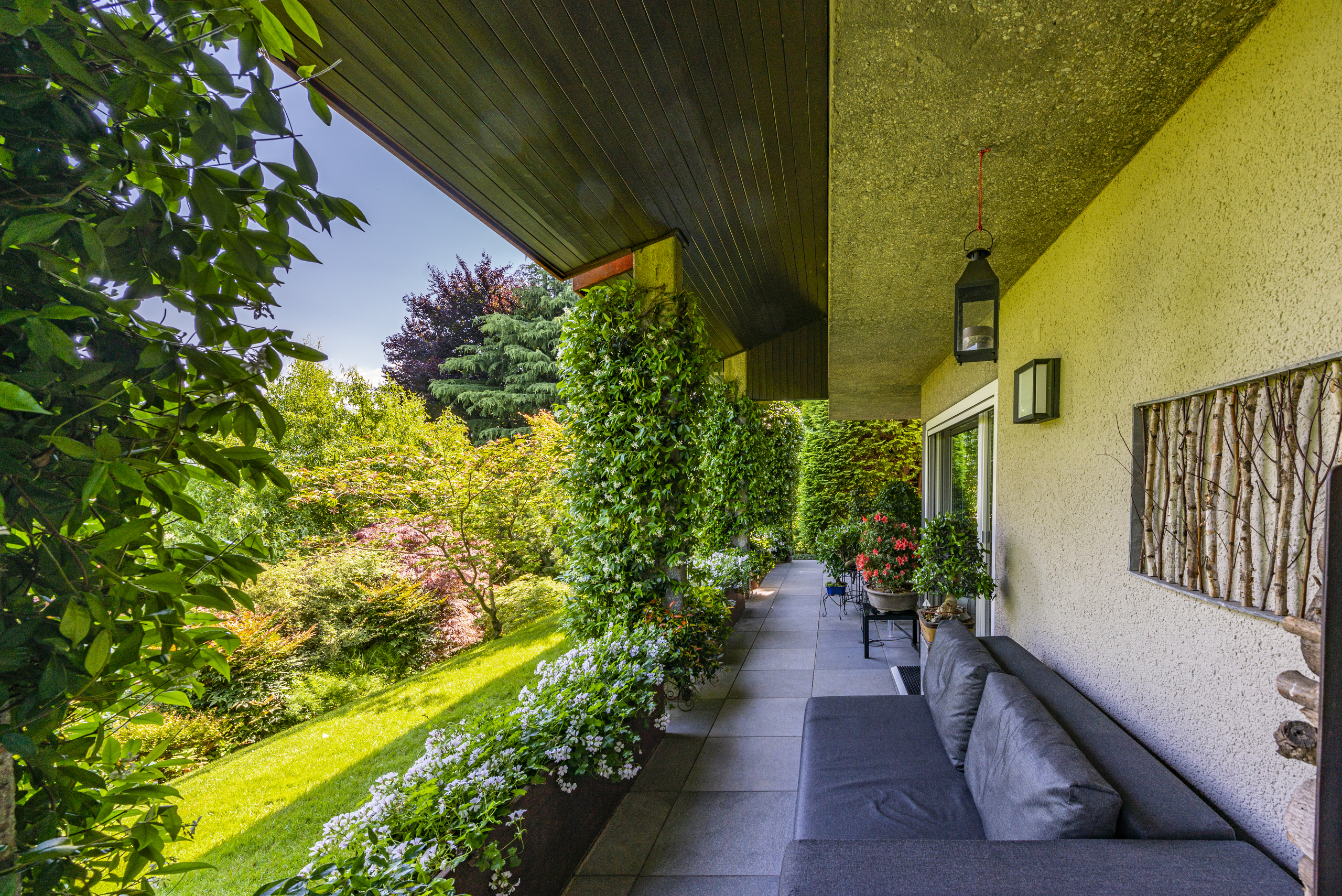 Überdachte Terrasse mit Gartenblick