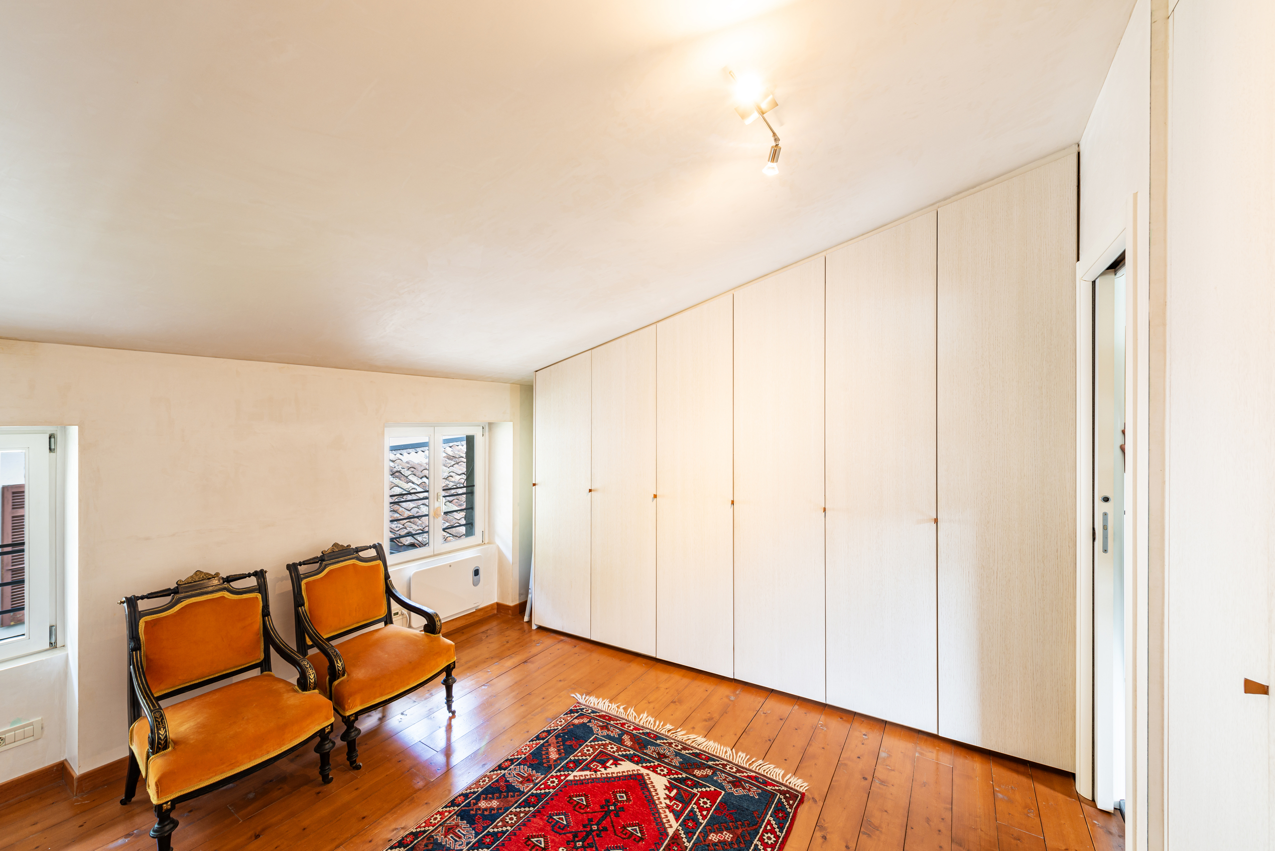 Helles Zimmer mit Einbauschrank und Holzfußboden