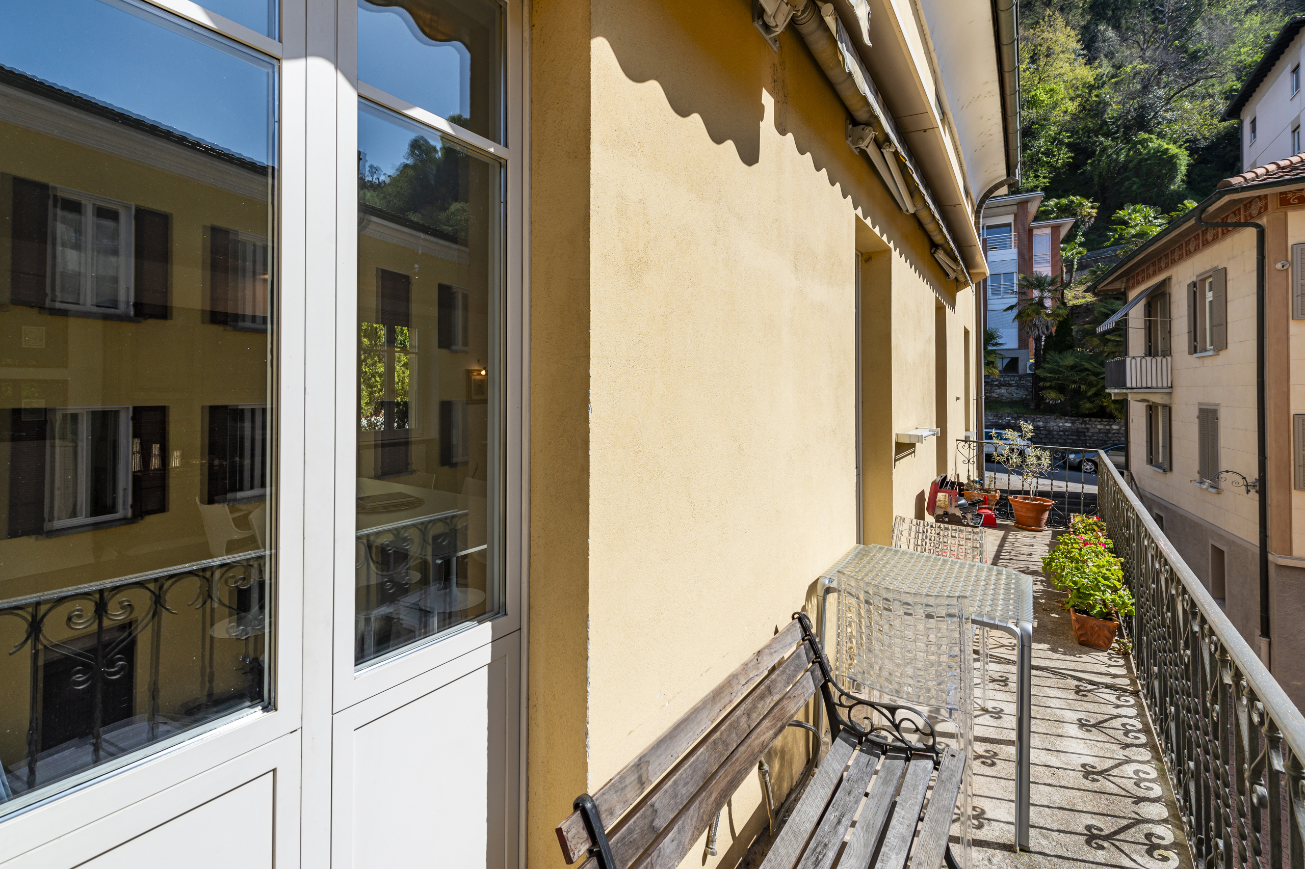 Balkon mit Blick auf Nachbargebäude und Grünhang