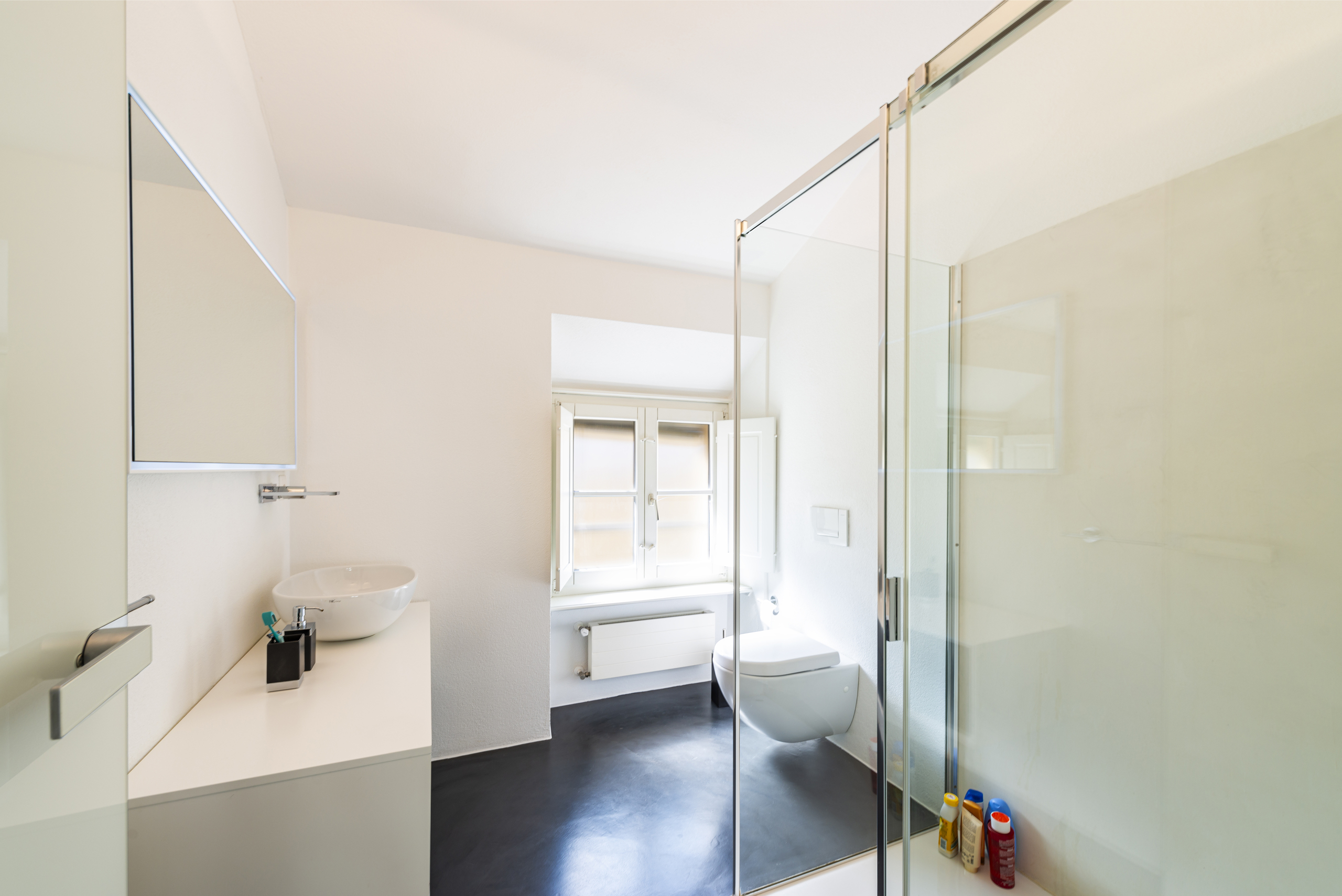 Modernes Badezimmer mit Glasdusche und Fenster