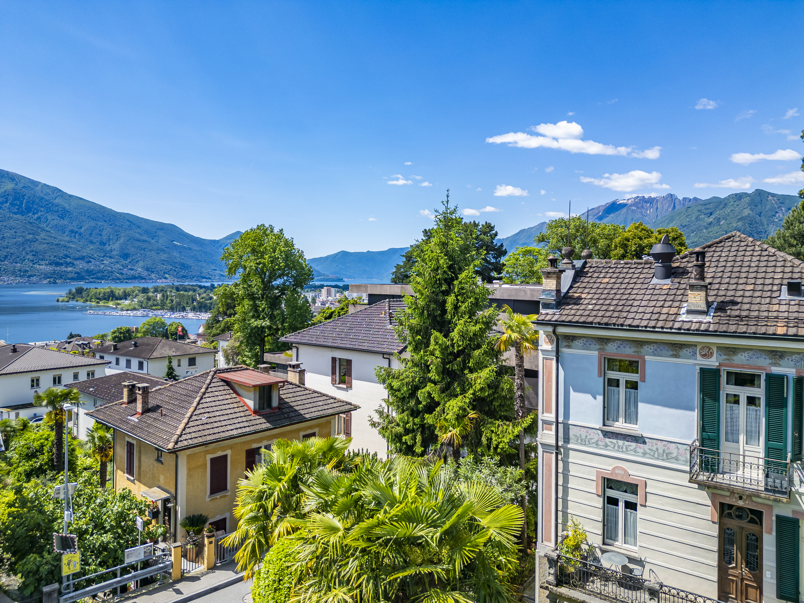 Seeblick über Wohnhäuser mit Bergen