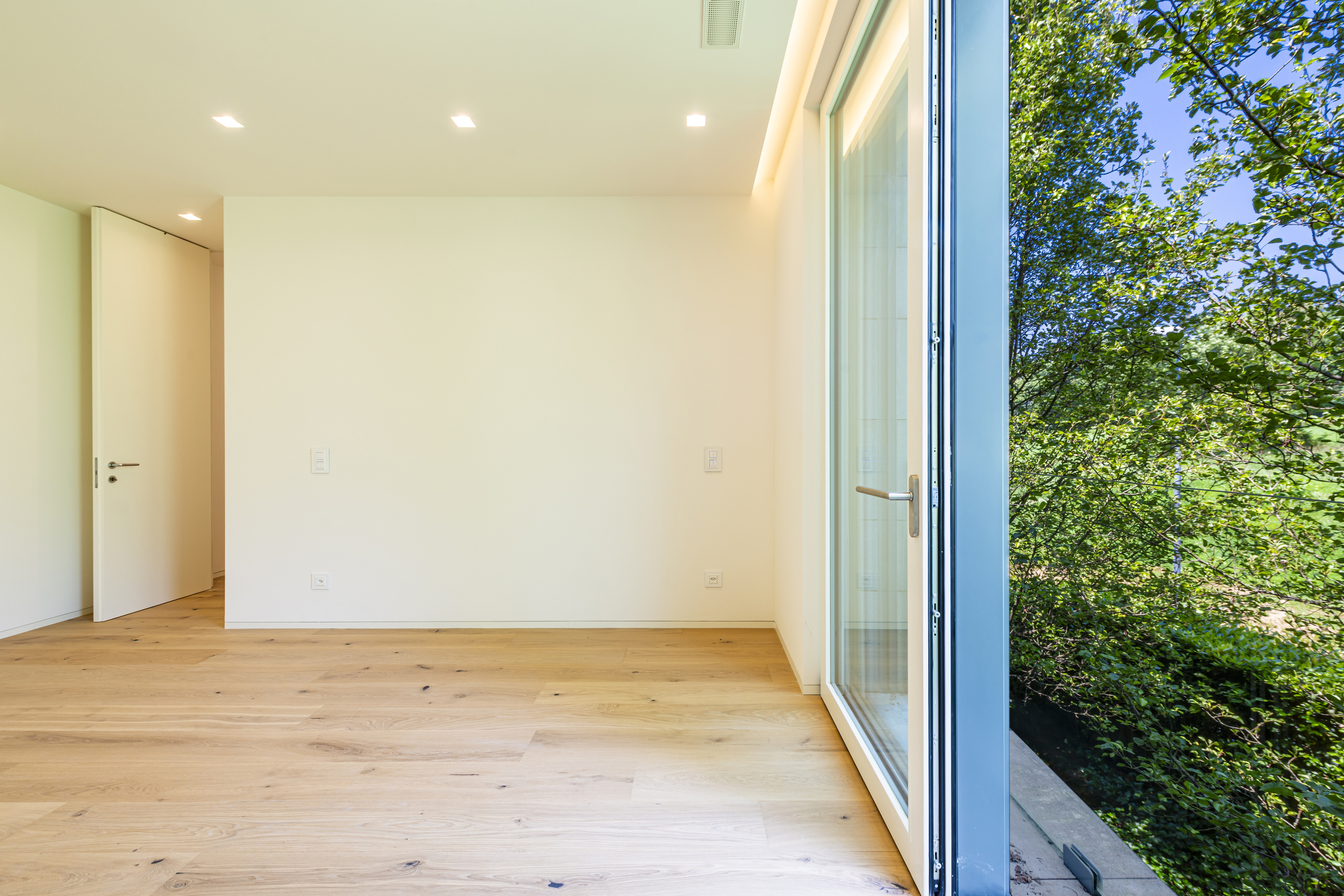 Helles, leeres Zimmer mit Balkonblick