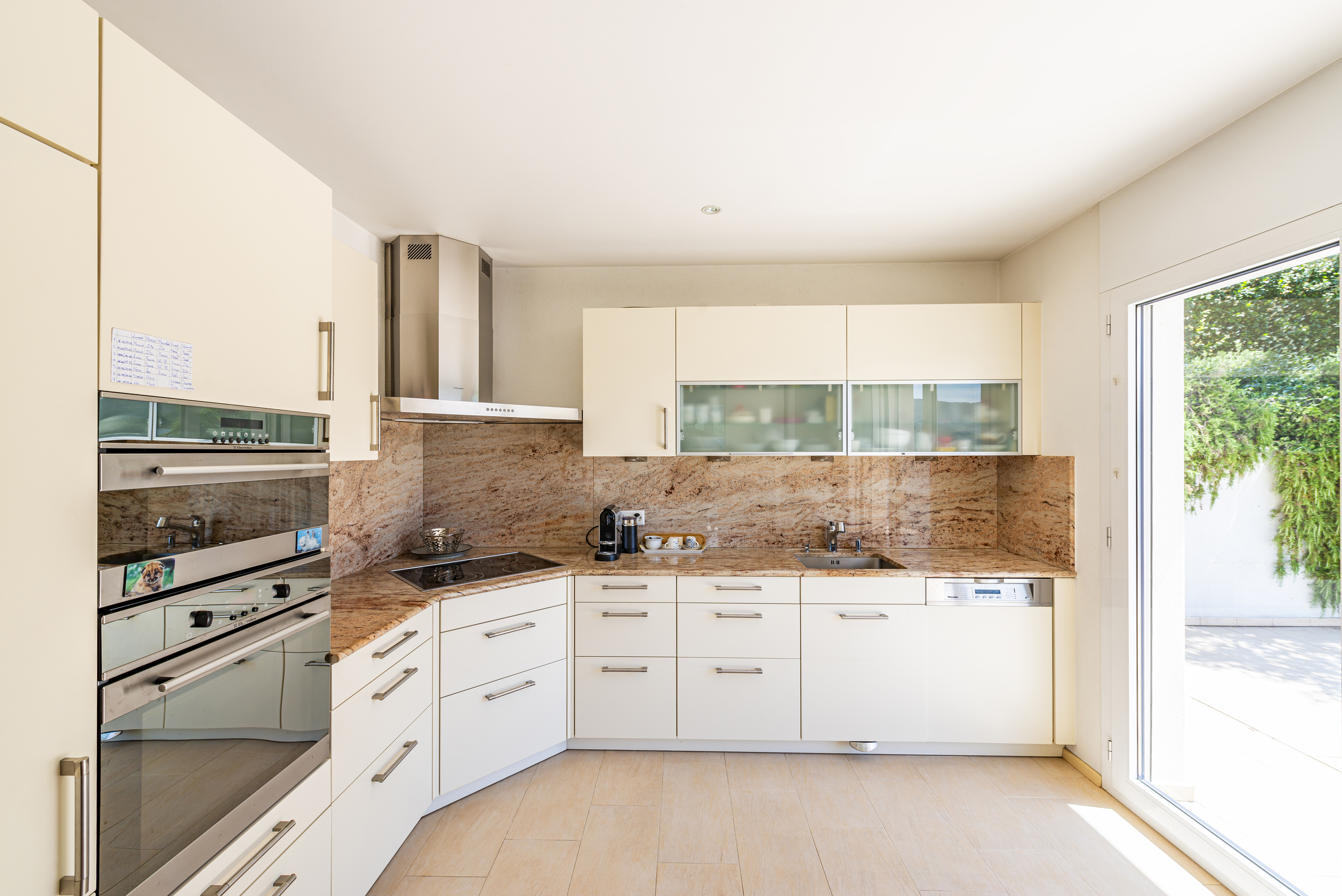 Helle, moderne Küche mit Naturstein und Glasfronten