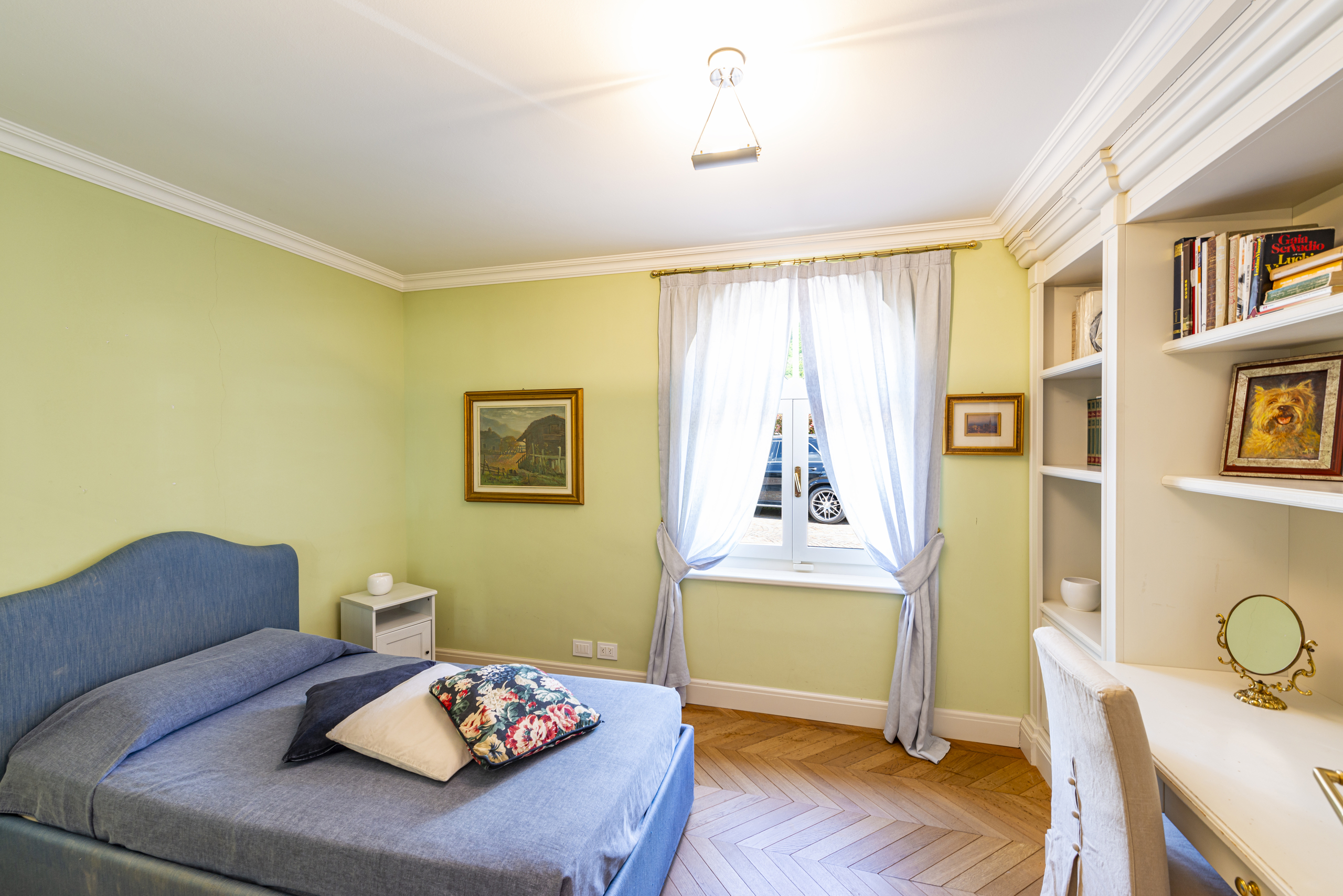 Helles Schlafzimmer mit blauem Bett und Einbauten