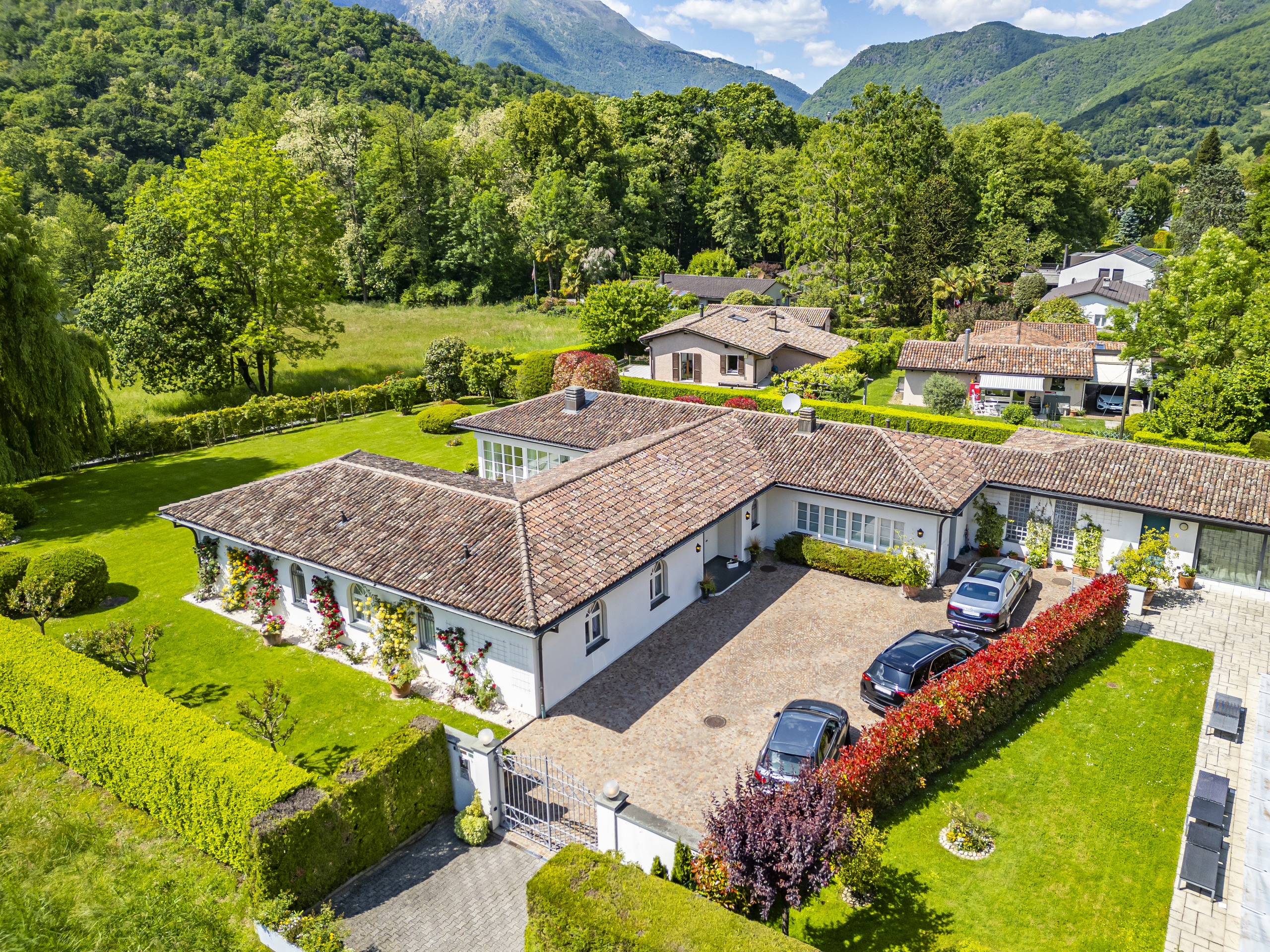 Luftaufnahme eines mediterranen Wohnanwesens in grüner Berglandschaft