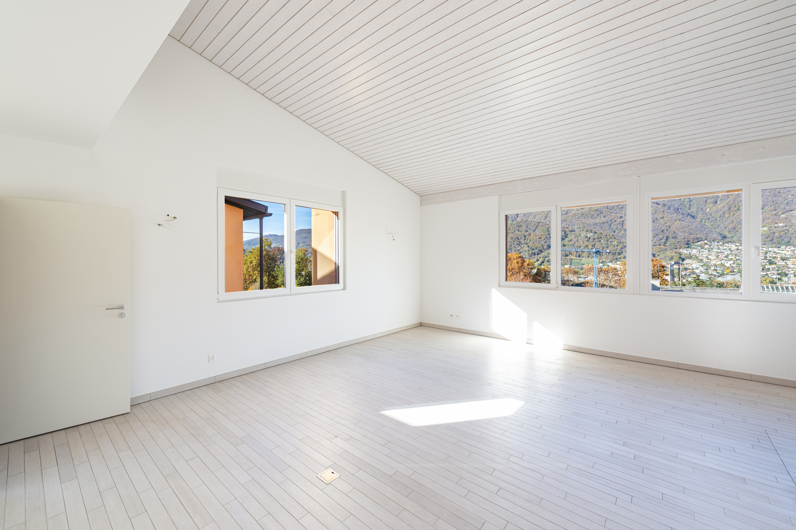 Heller leerer Raum mit Panoramafenstern und Bergblick