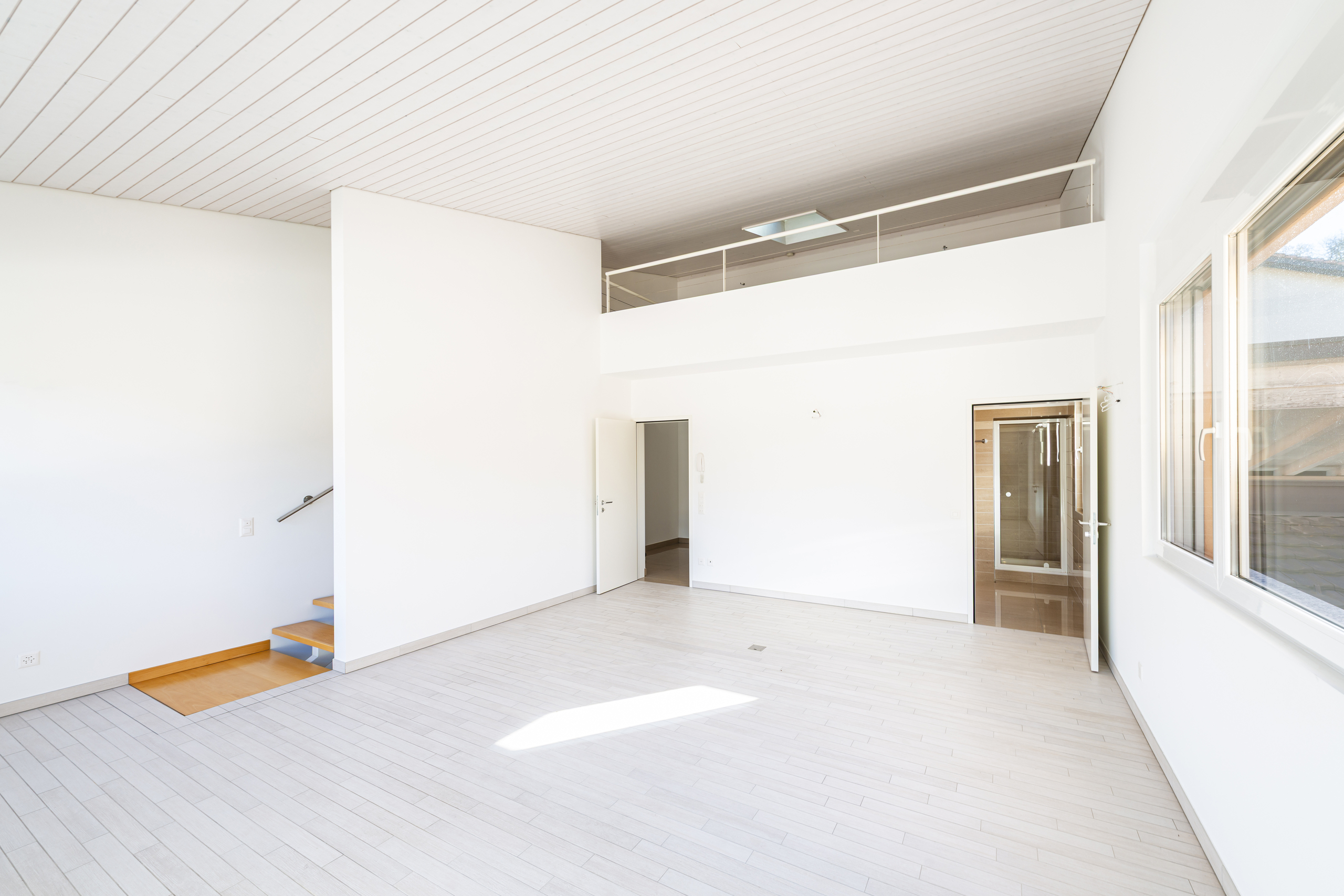 Heller, leerer Innenraum mit Galerie und Treppe