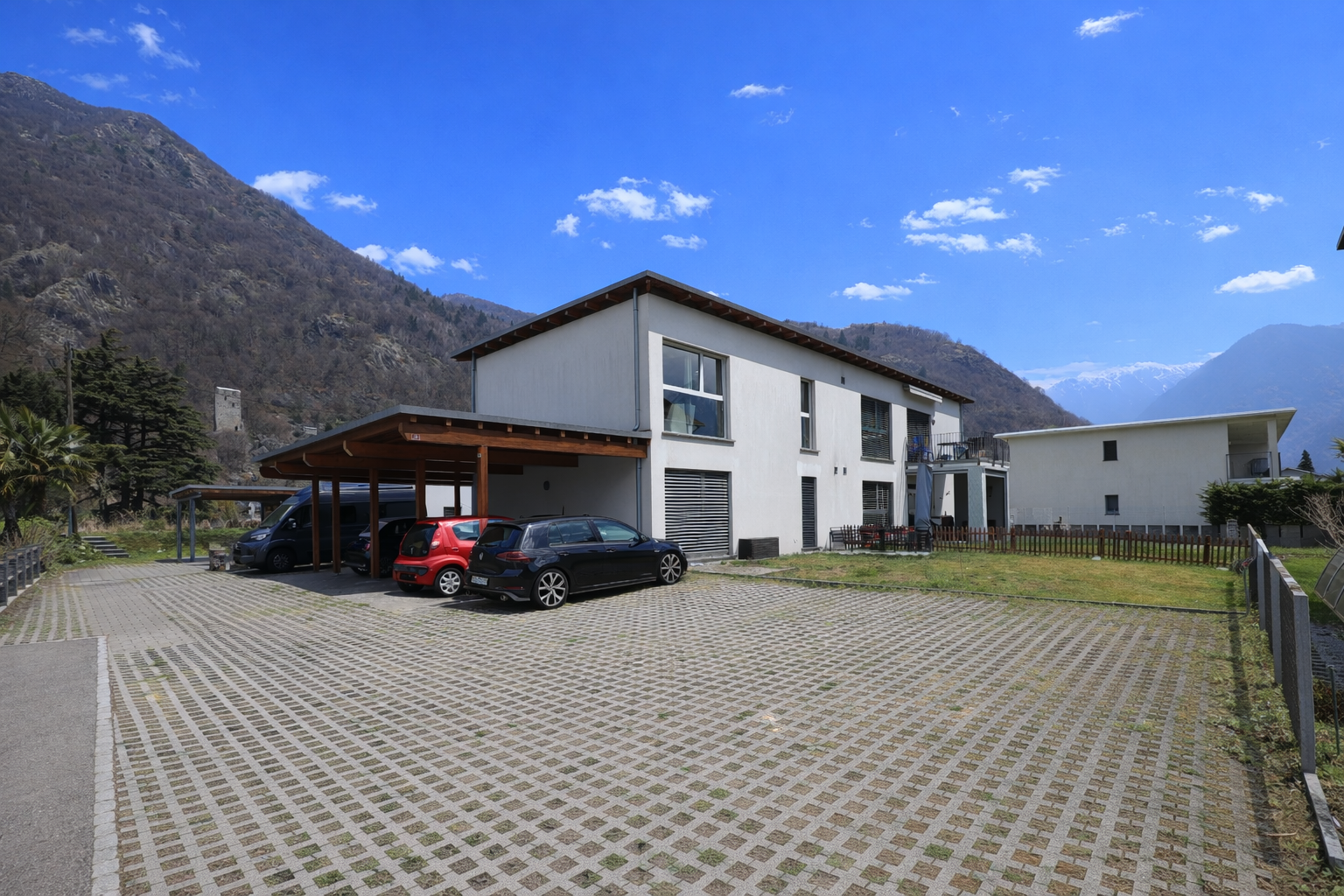 Modernes Haus mit Bergkulisse und großer Zufahrt