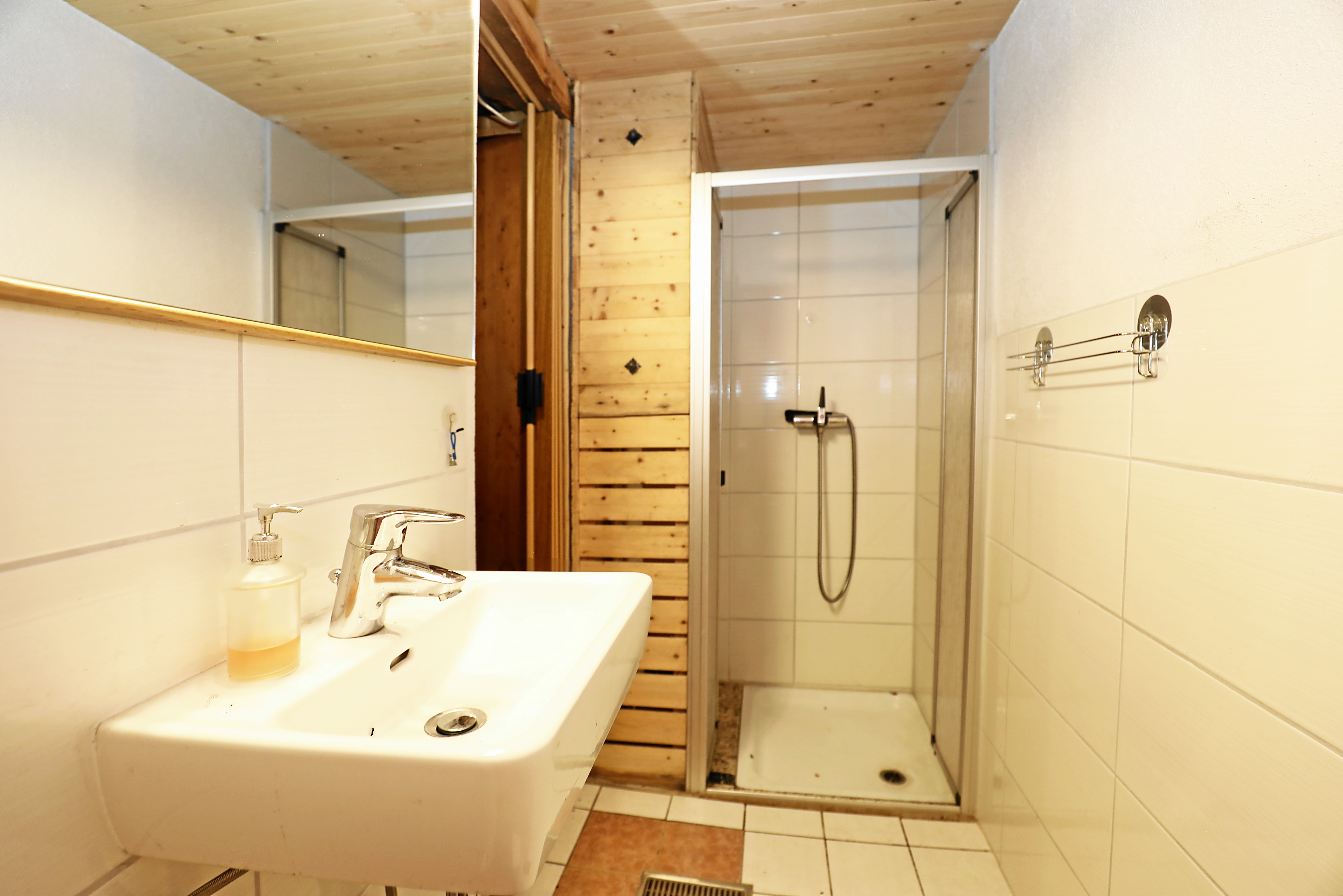 Kleines Bad mit Dusche und Waschbecken