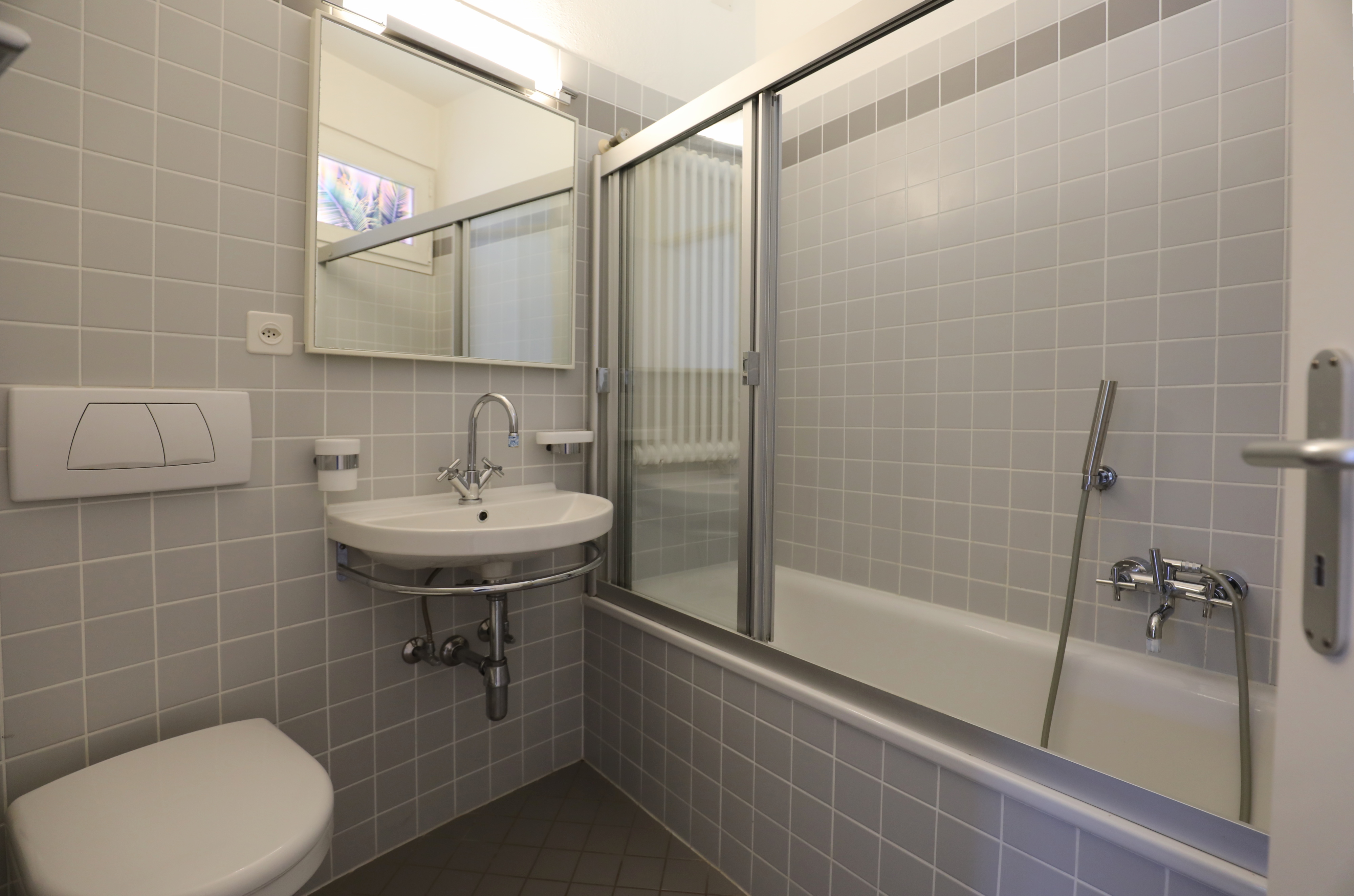 Kleines helles Badezimmer mit Badewanne und Waschbecken