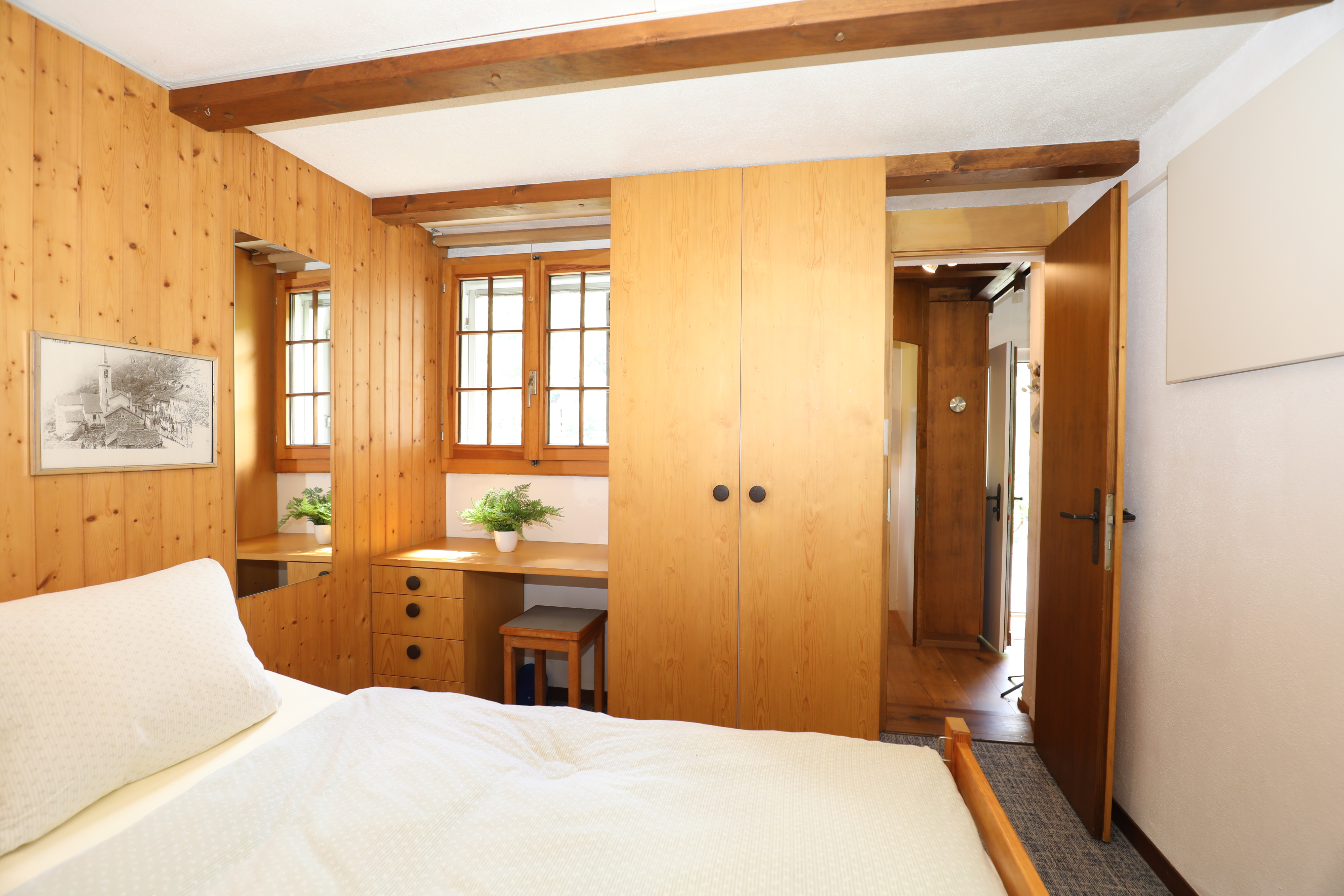 Gemütliches Schlafzimmer mit viel Holz und Einbauschrank