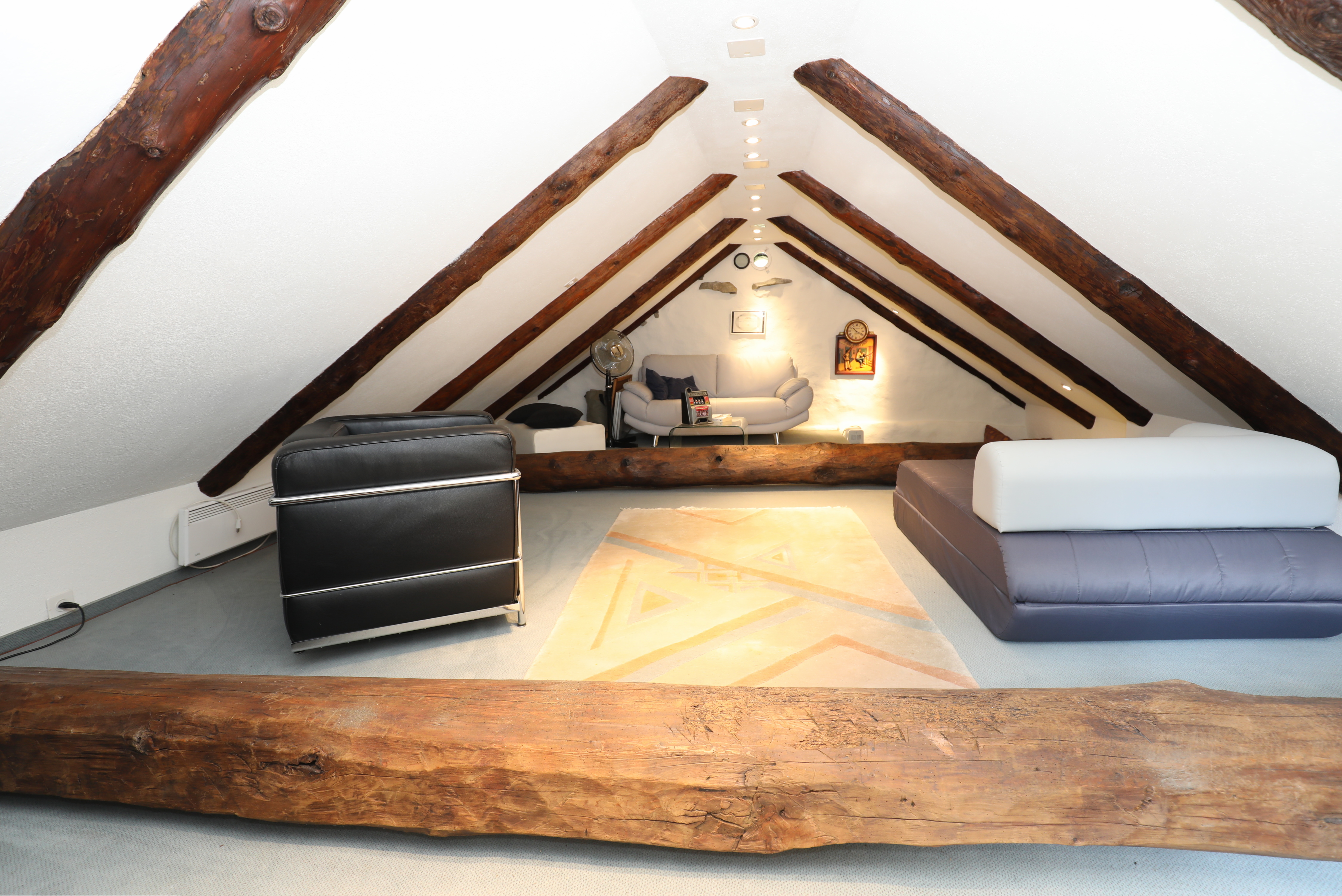 Dachgeschoss-Lounge mit sichtbaren Holzbalken