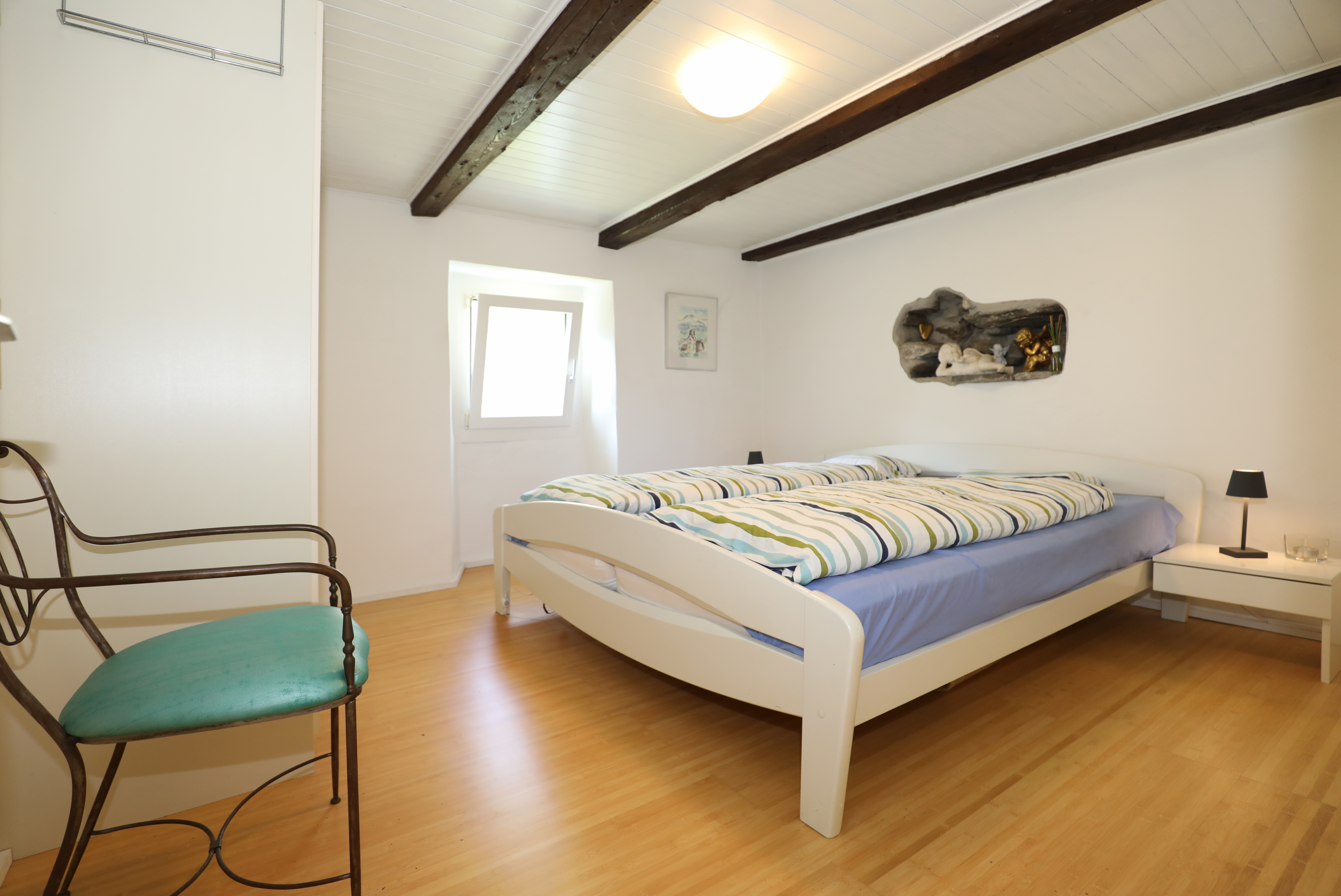 Helles Schlafzimmer mit sichtbaren Holzbalken