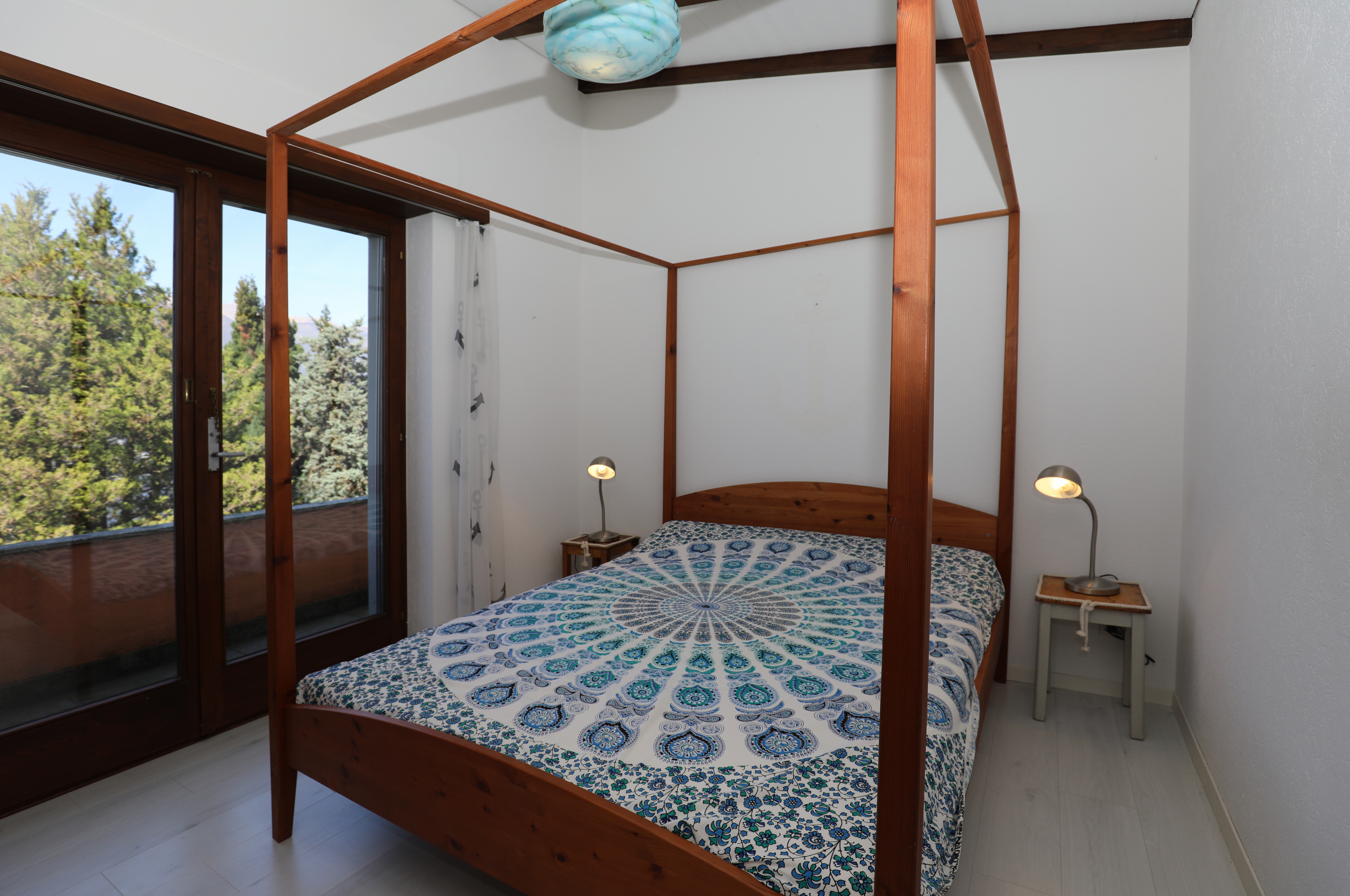 Schlafzimmer mit Himmelbett und Balkonblick