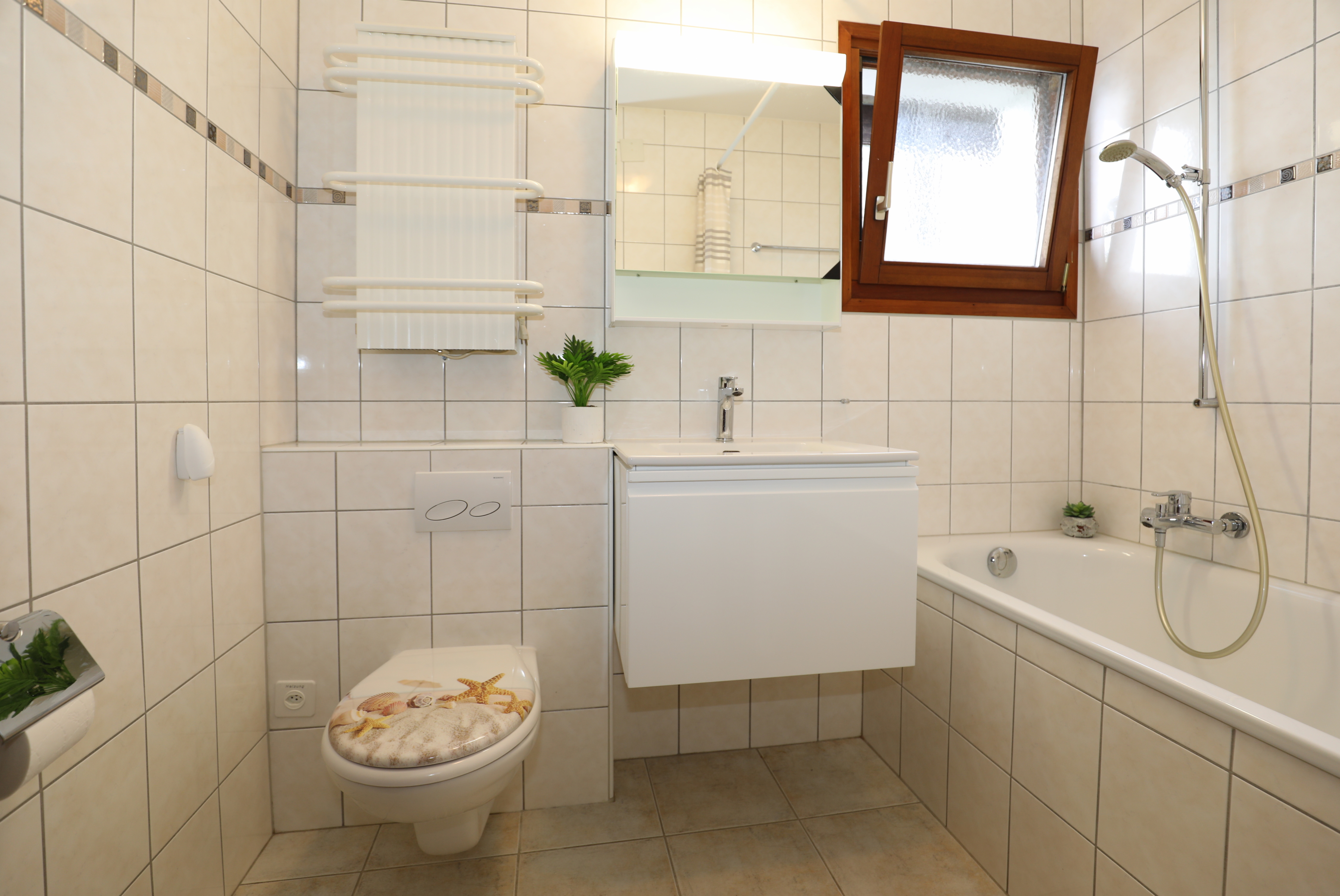 Helles Badezimmer mit Badewanne und Fenster