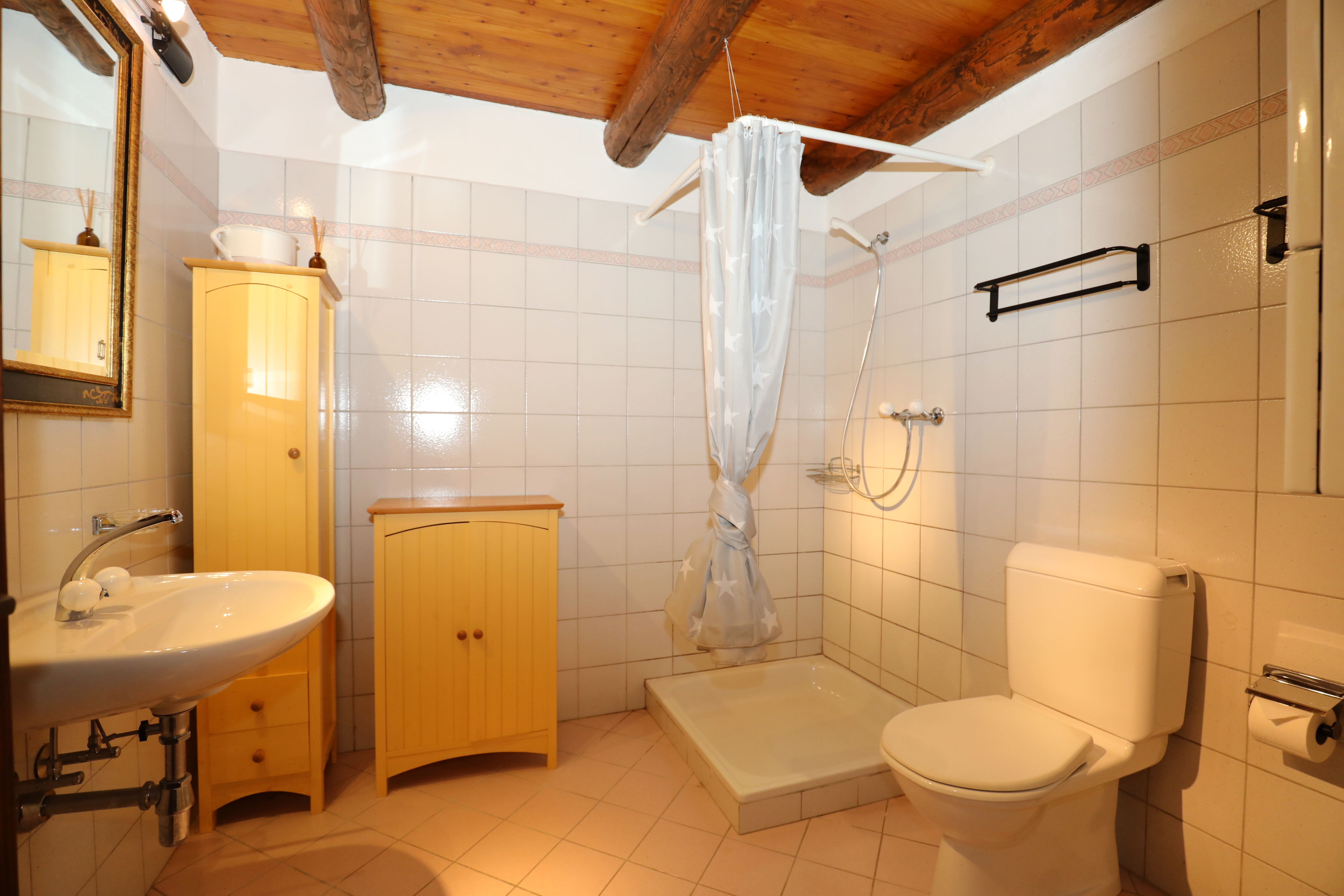 Badezimmer mit rustikalem Balkendecken-Charakter