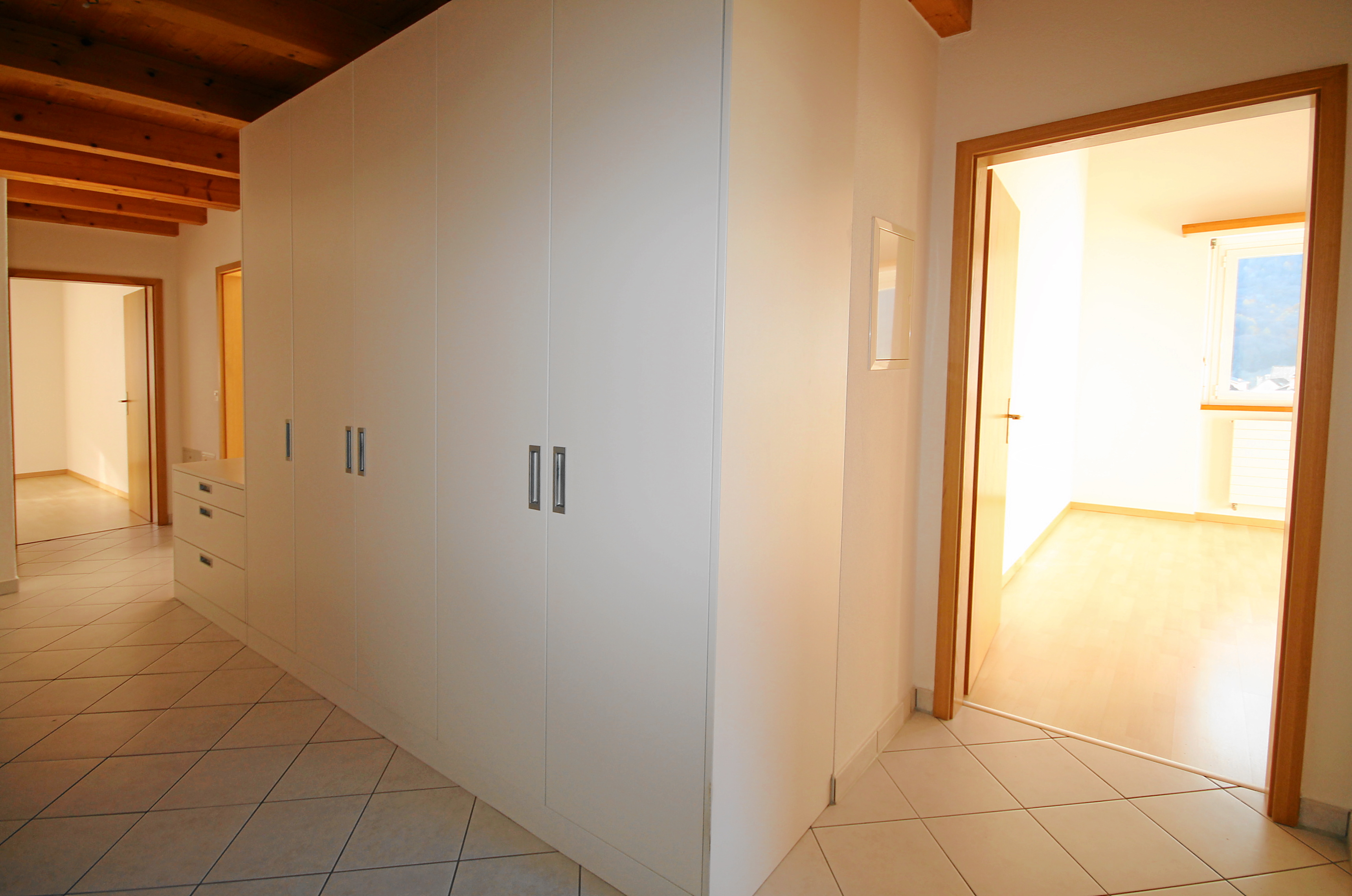 Heller Flur mit Einbauschrank und Holzbalkendecke