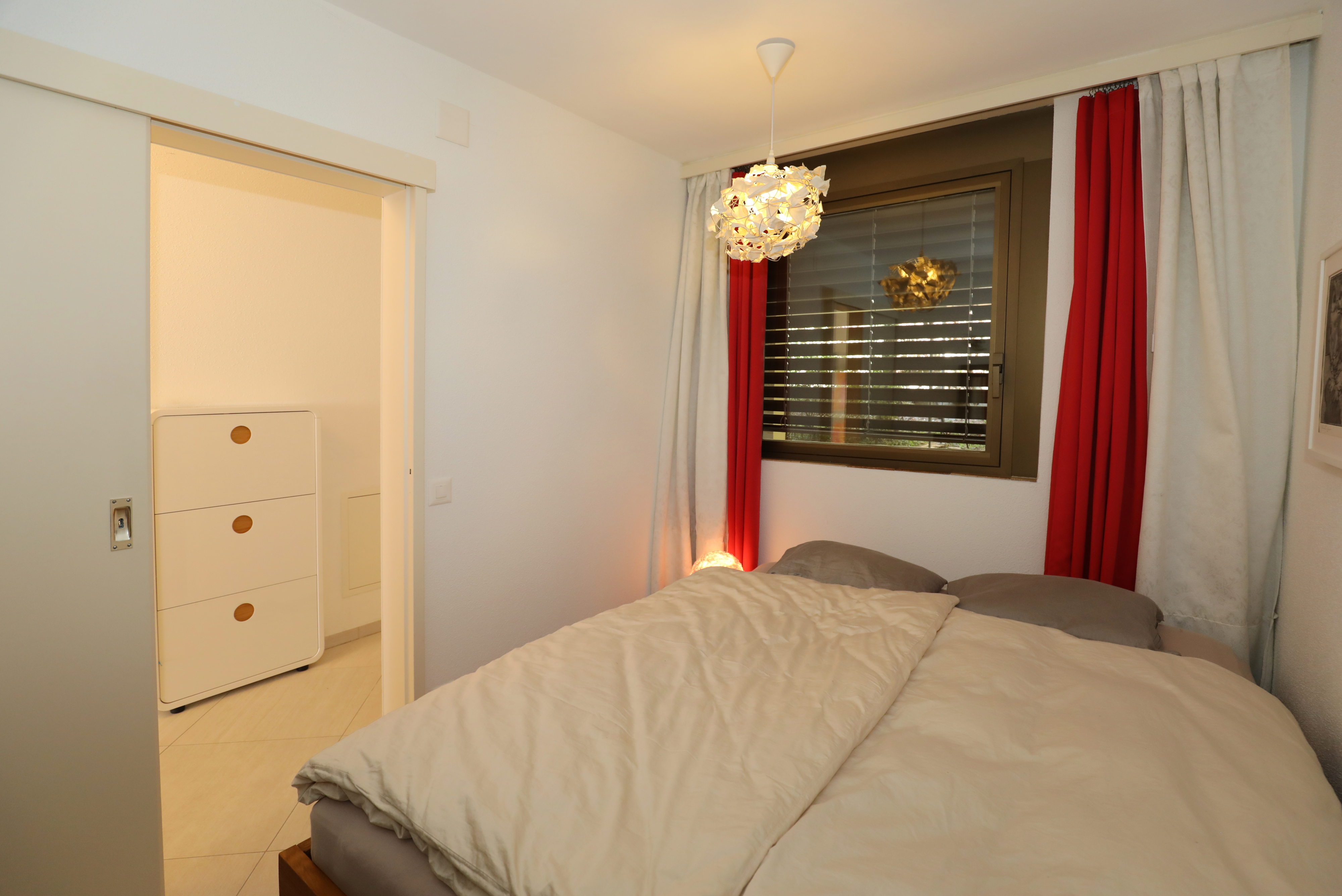 Kleines Schlafzimmer mit Bett und Fenster