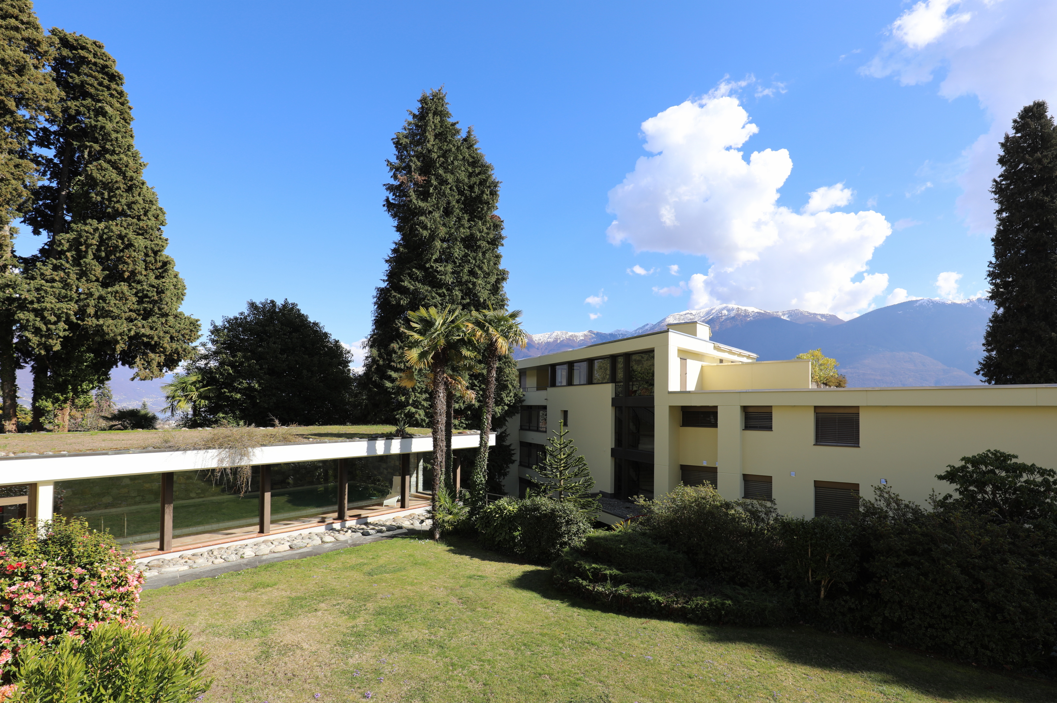 Moderner Gebäudekomplex mit Garten und Bergblick