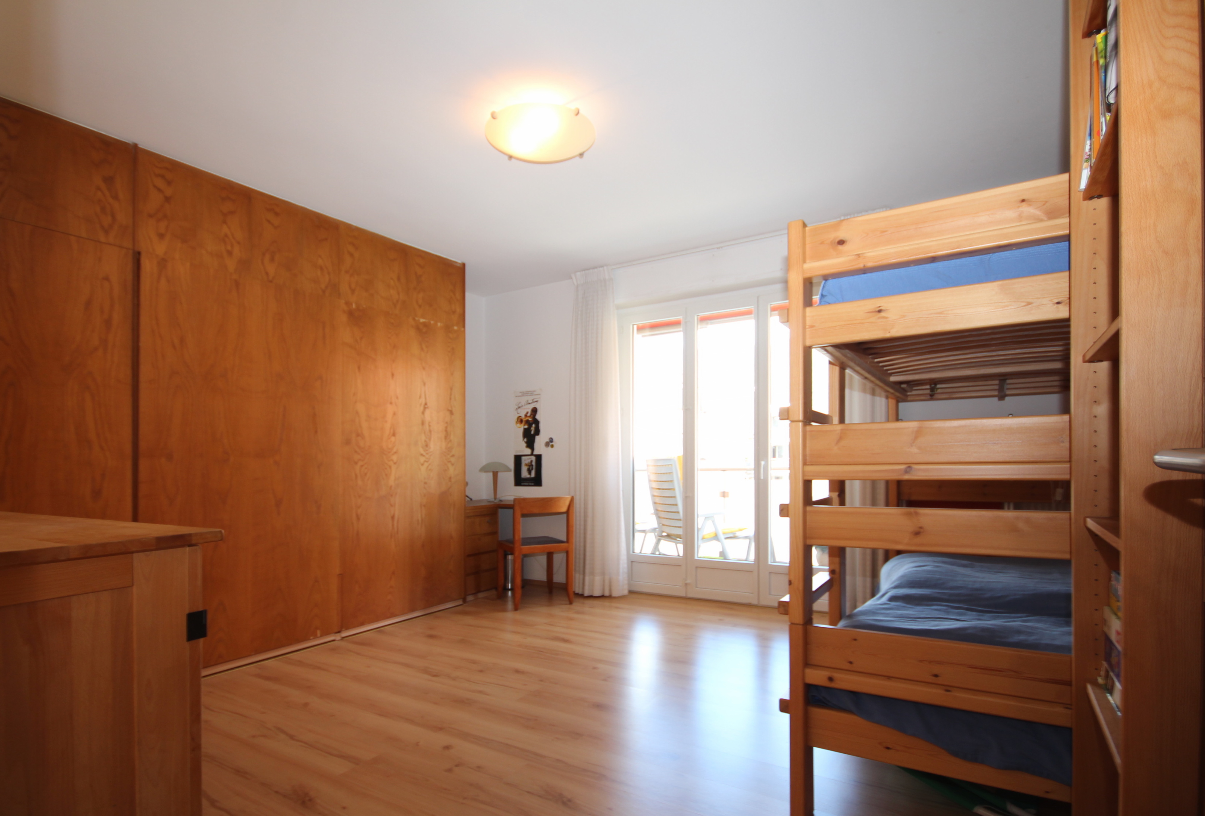 Kinderzimmer mit Hochbett und Holzschrankwand