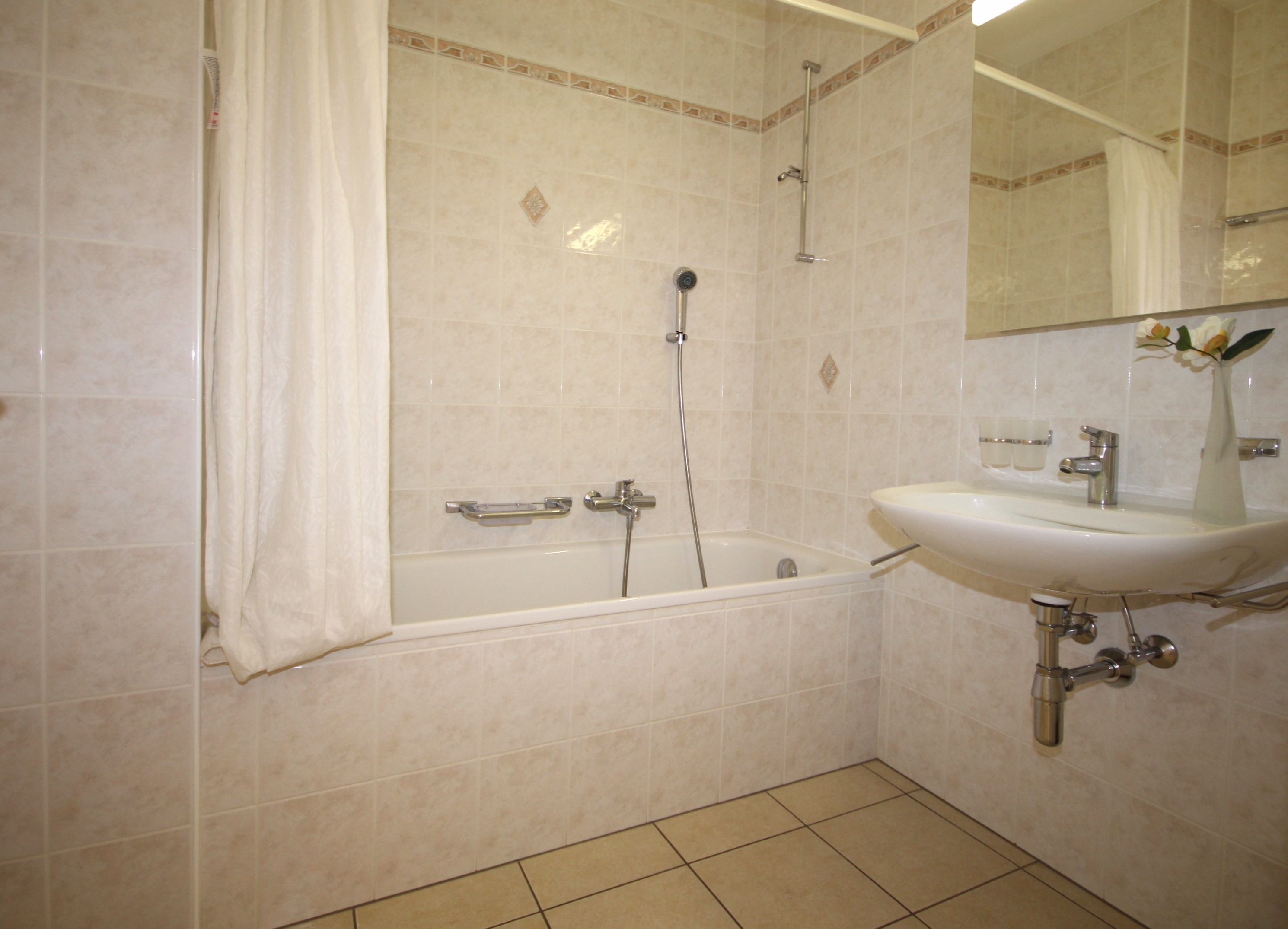 Badezimmer mit Wanne und Waschtisch