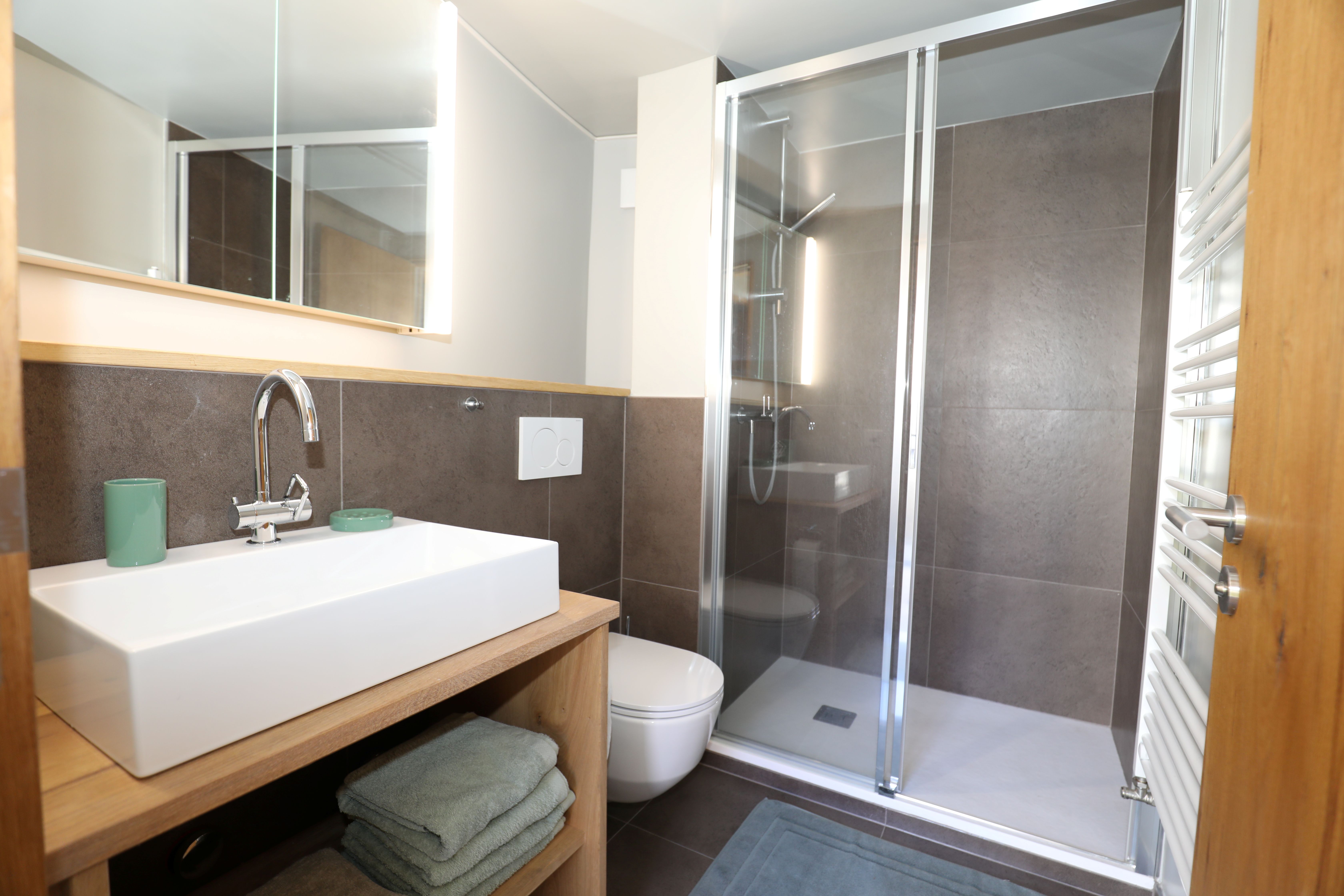 Modernes Badezimmer mit Dusche und Holzwaschtisch