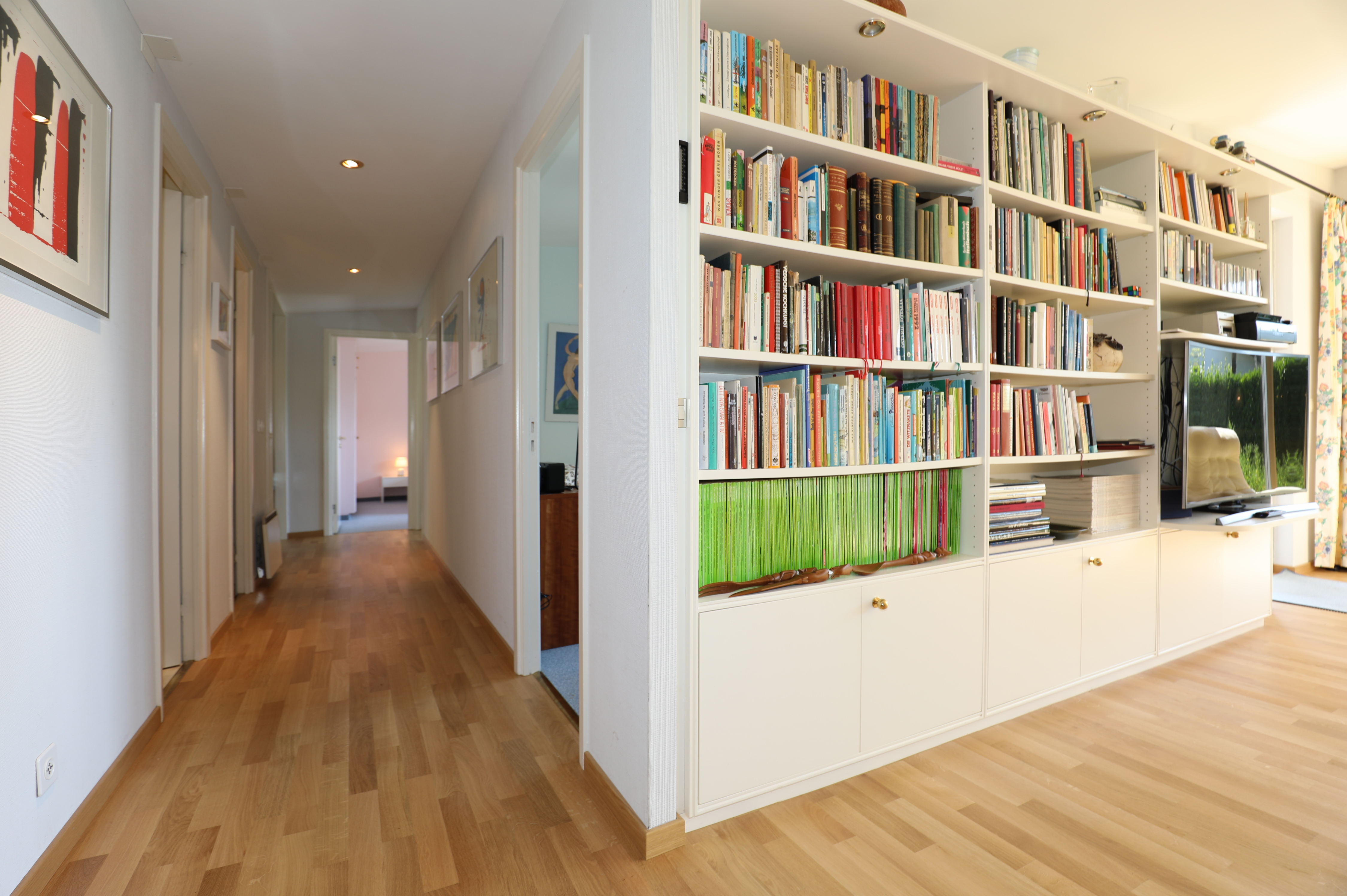 Heller Flur mit Bibliothekswand