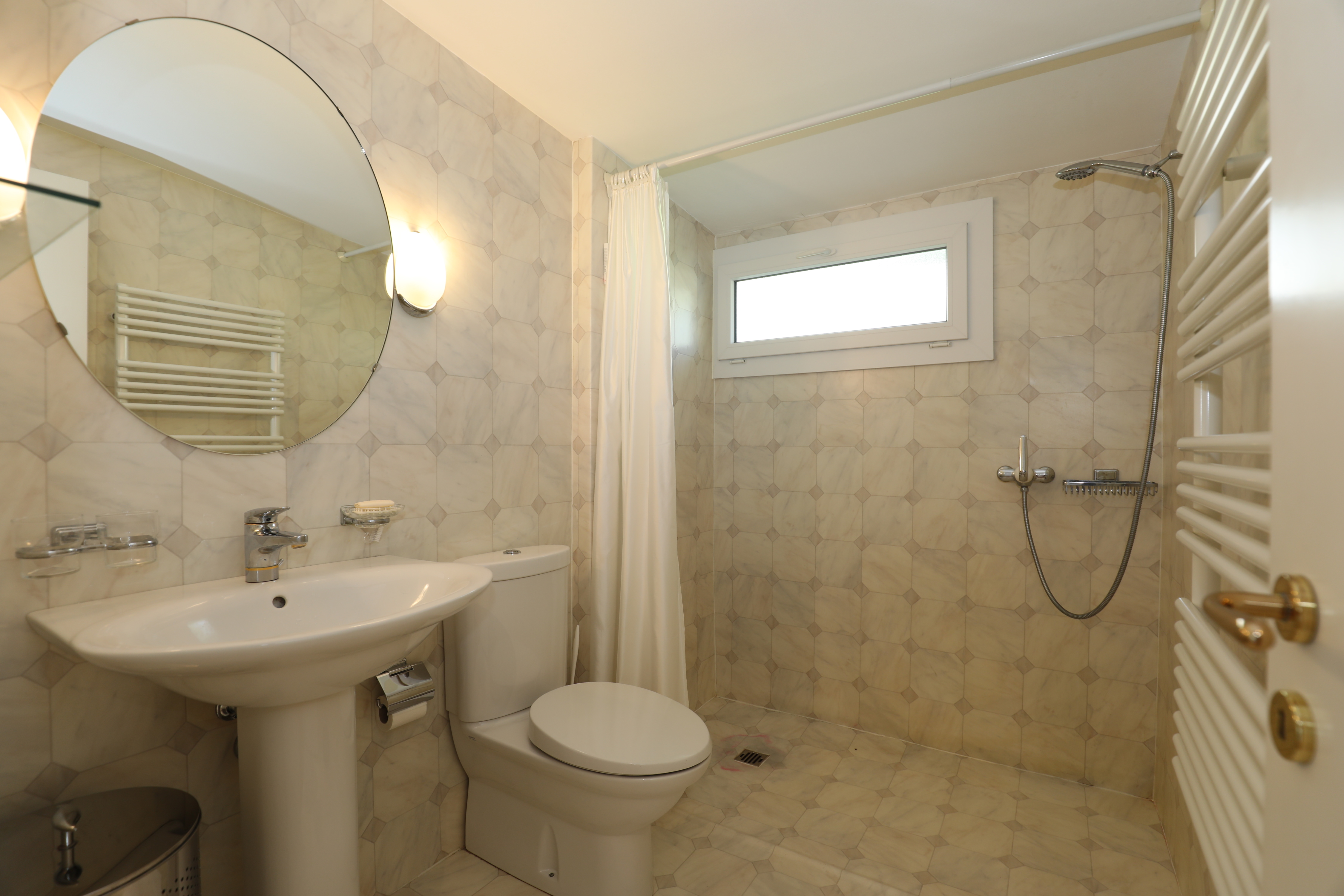Helles Badezimmer mit Dusche, WC und Waschbecken