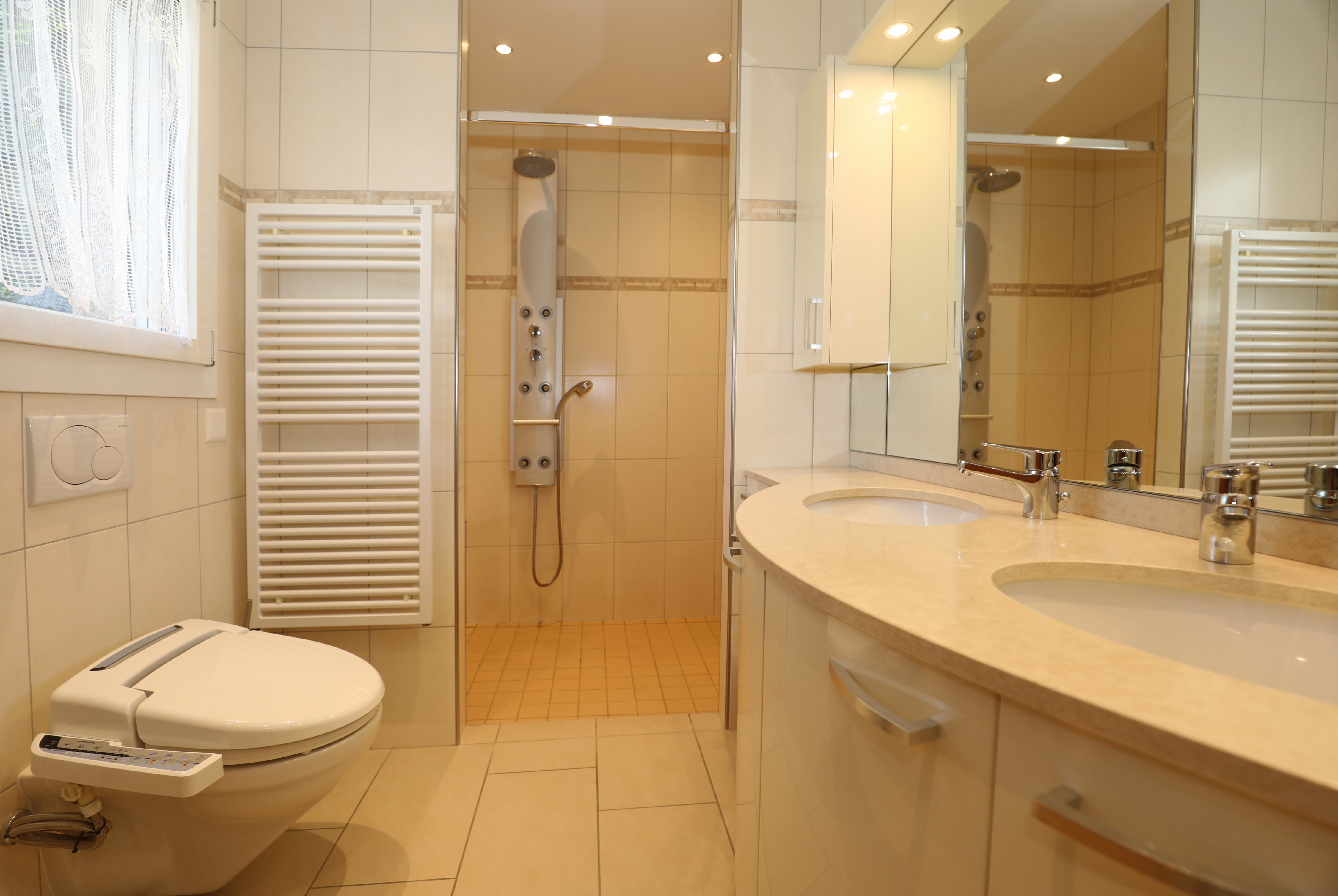 Helles Badezimmer mit Doppelwaschtisch und Dusche